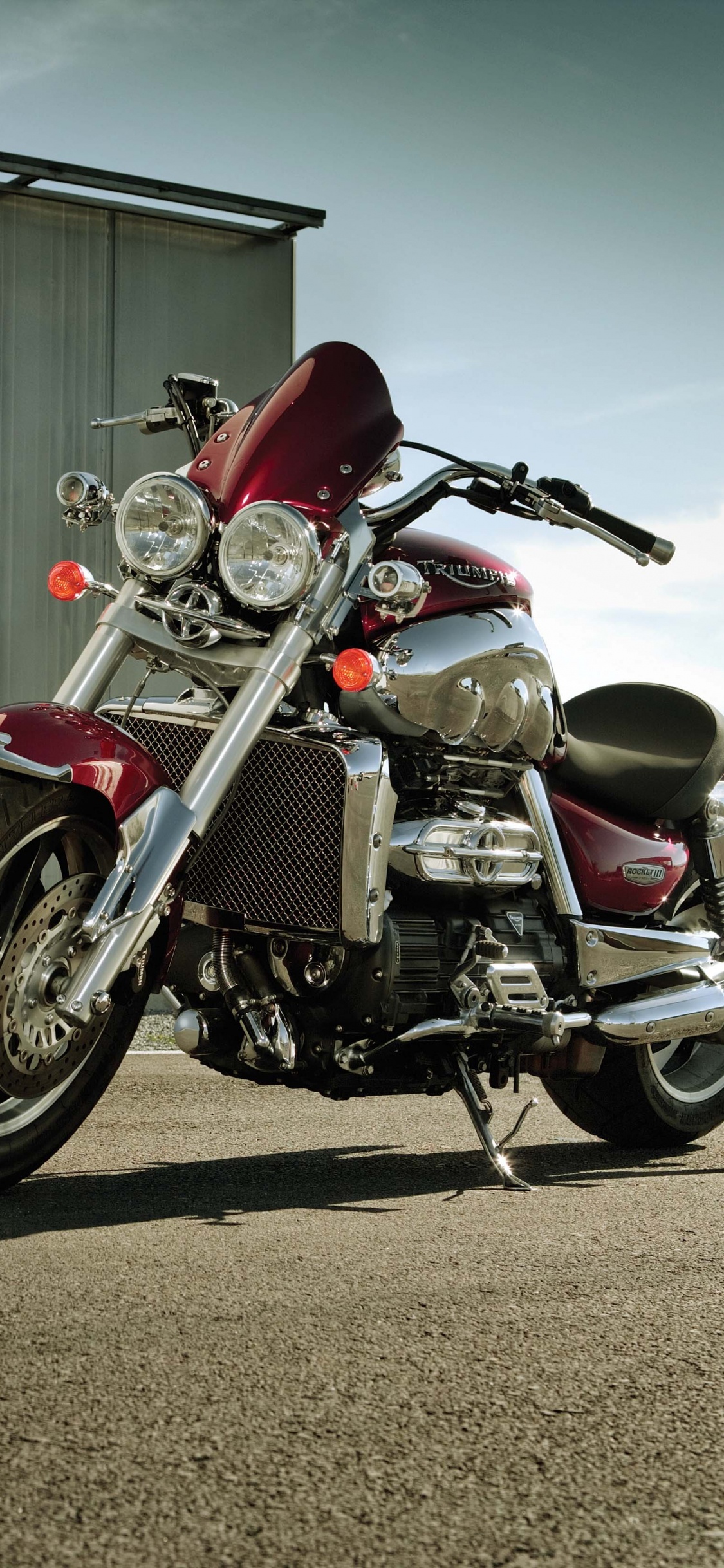 Red and Black Motorcycle Parked Beside White Wall. Wallpaper in 1125x2436 Resolution