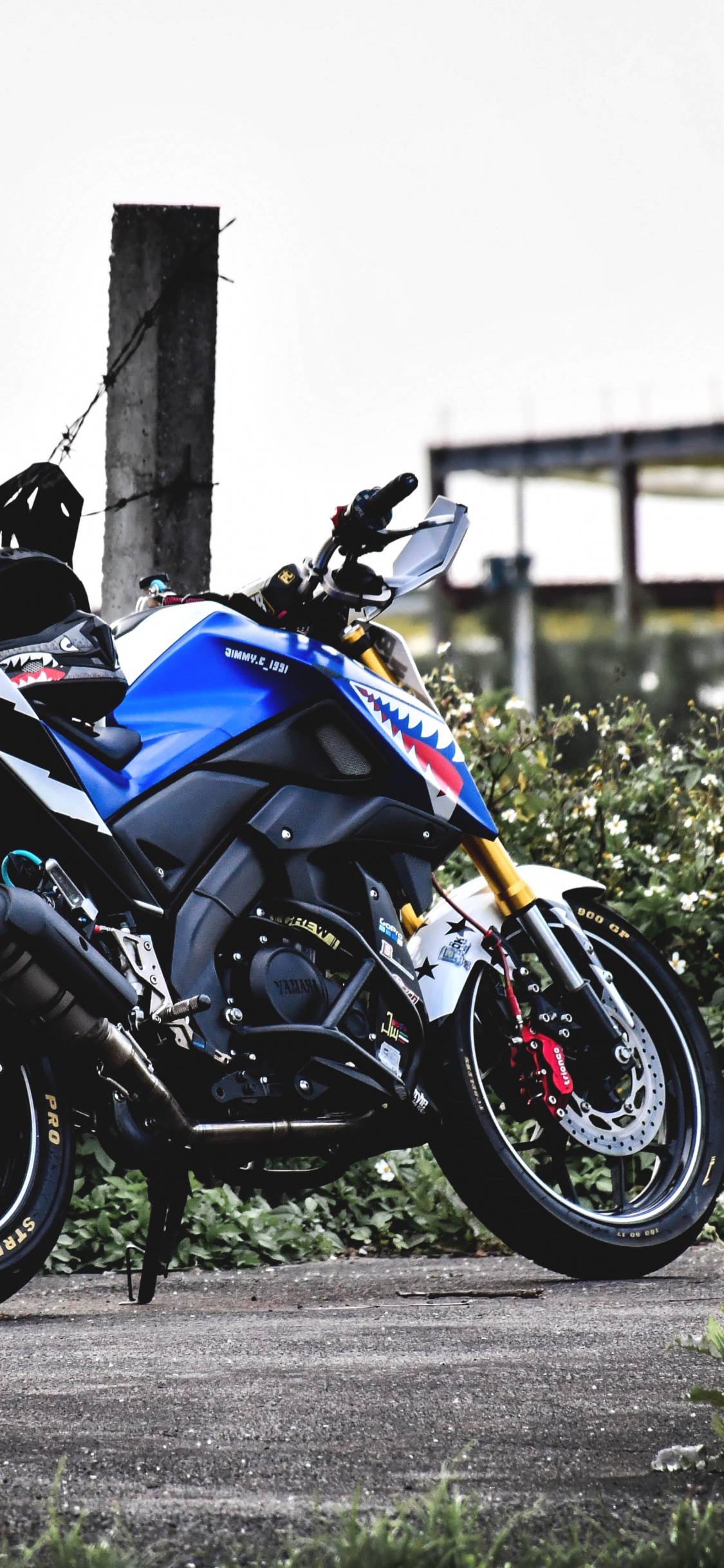 Black and Blue Sports Bike Parked on Gray Concrete Road During Daytime. Wallpaper in 1125x2436 Resolution