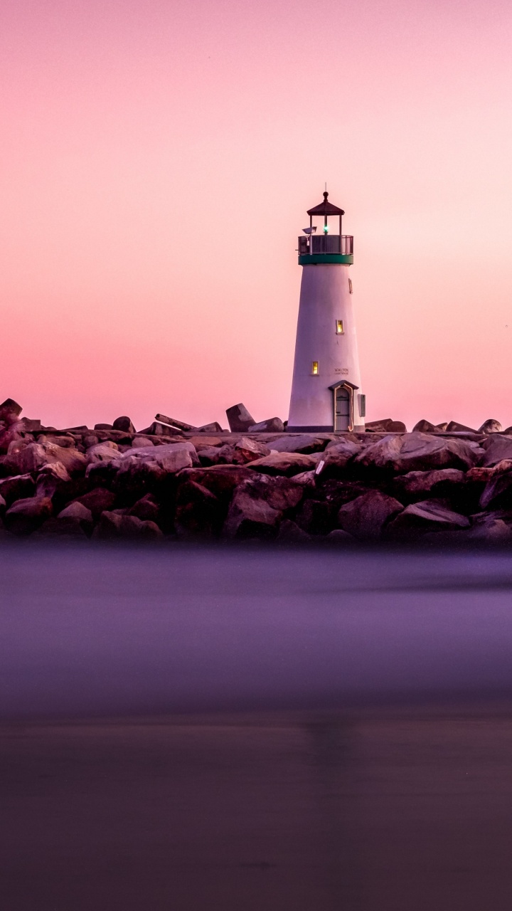 White Lighthouse on Brown Rock Formation Near Body of Water During Daytime. Wallpaper in 720x1280 Resolution