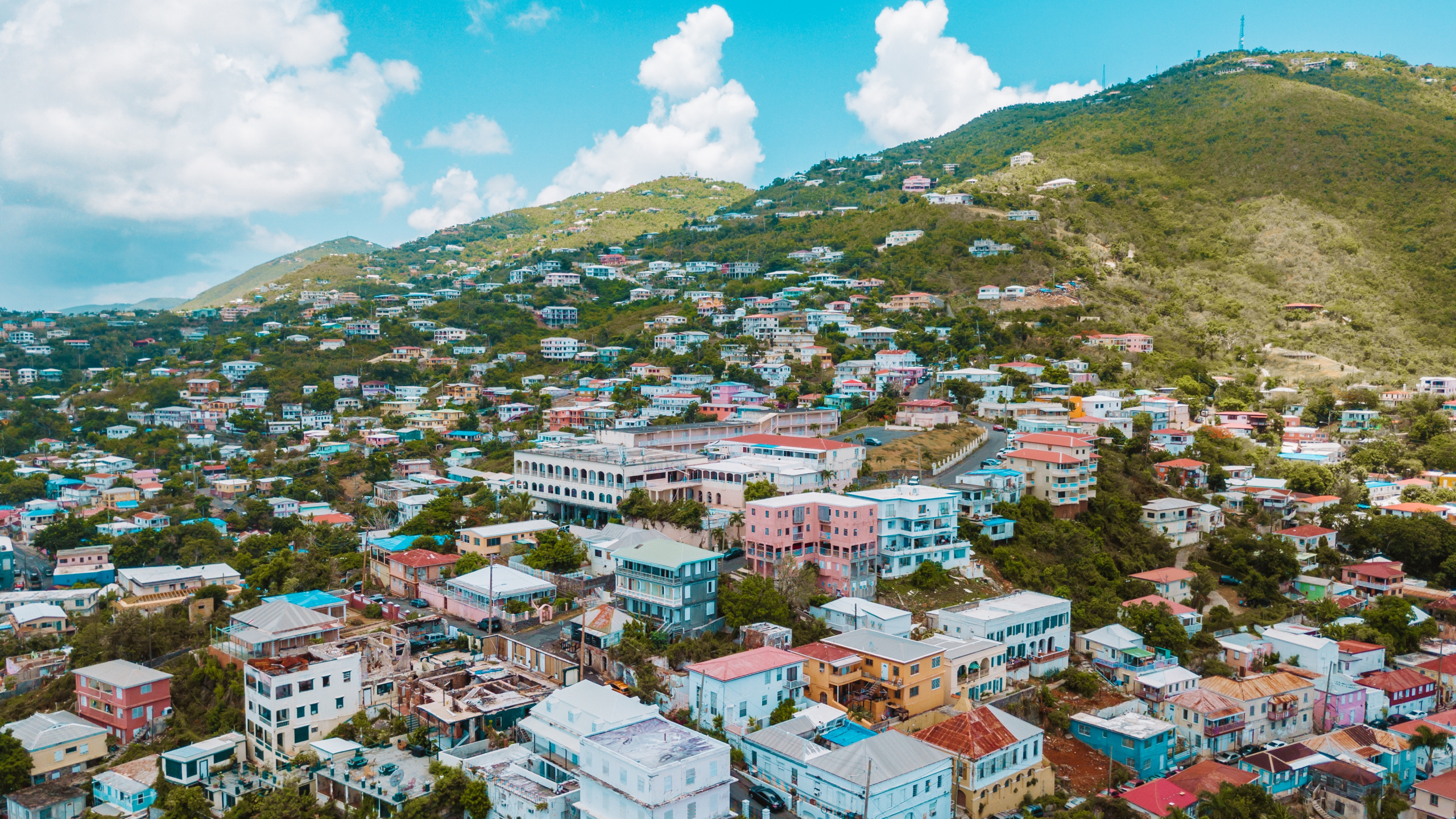 Vue Aérienne Des Bâtiments de la Ville Sur la Montagne Verte Pendant la Journée. Wallpaper in 2560x1440 Resolution