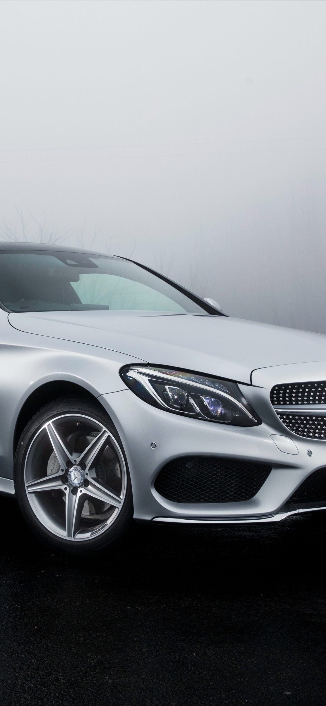 Mercedes Benz Coupe Plateado Sobre Carretera Asfaltada Negra. Wallpaper in 1125x2436 Resolution