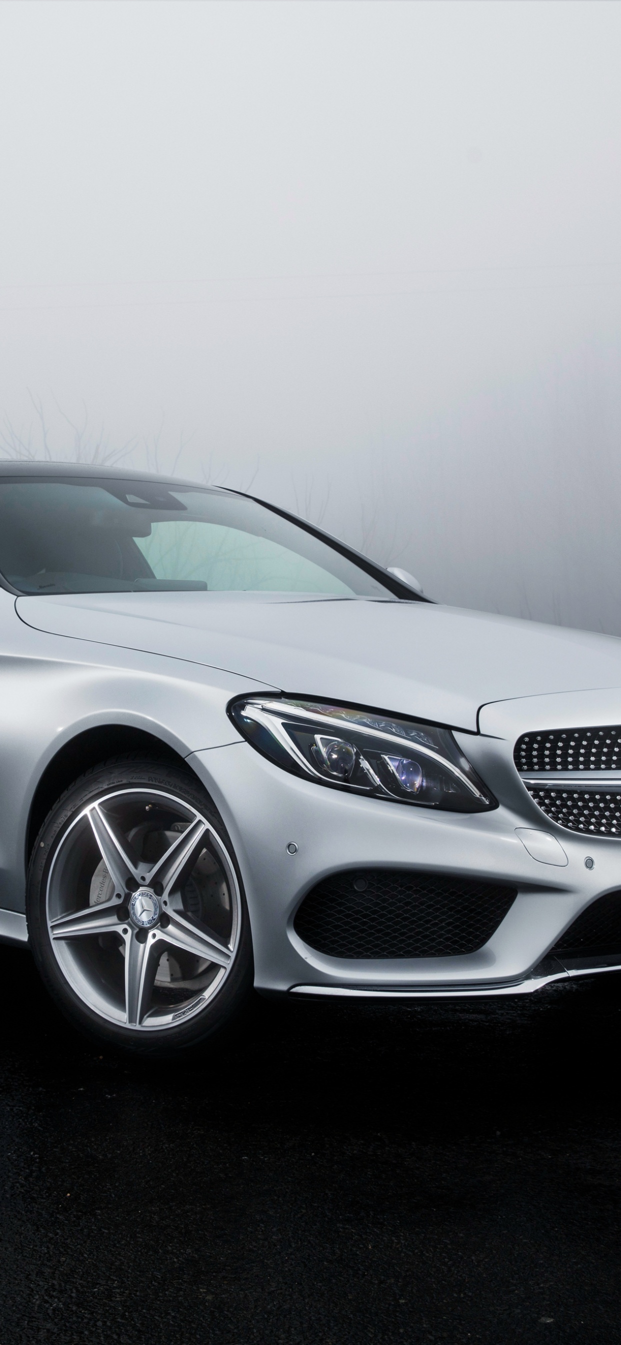 Mercedes Benz Coupe Plateado Sobre Carretera Asfaltada Negra. Wallpaper in 1242x2688 Resolution