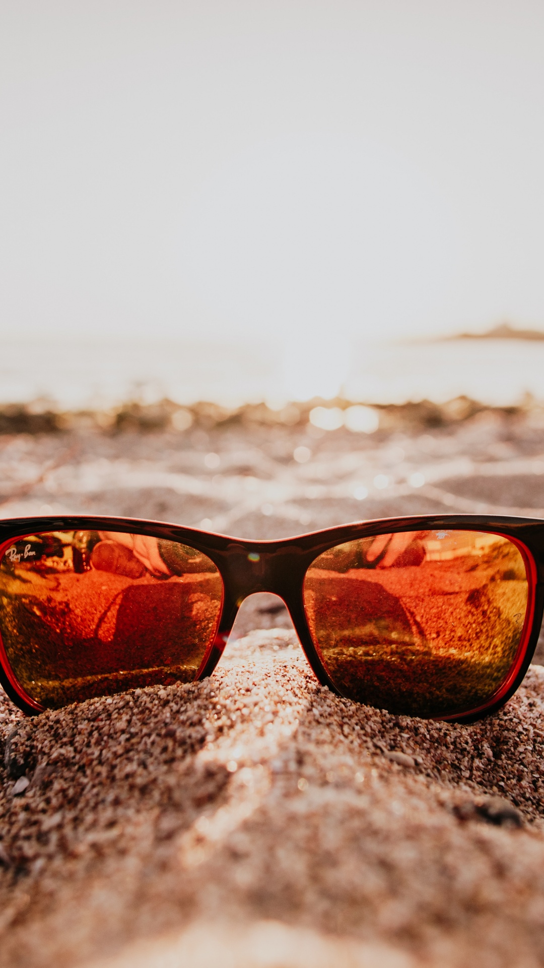 Sonnenbrille Mit Schwarzem Rahmen am Strand Bei Sonnenuntergang. Wallpaper in 1080x1920 Resolution