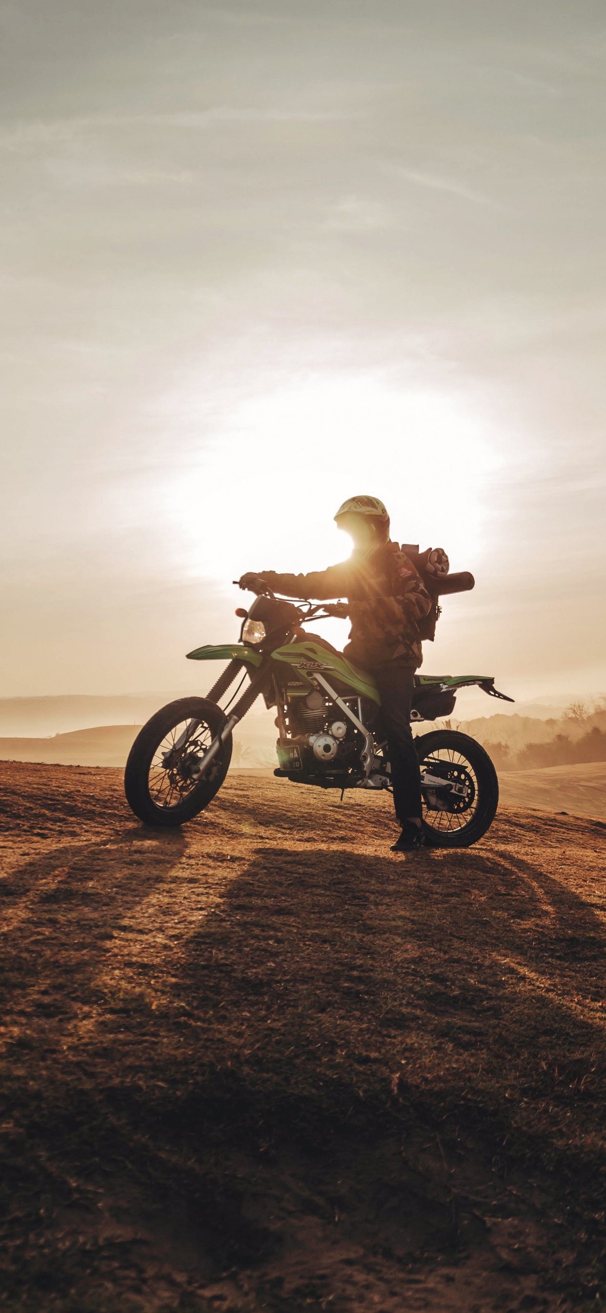 Man Riding Motorcycle on Brown Sand During Daytime. Wallpaper in 1242x2688 Resolution