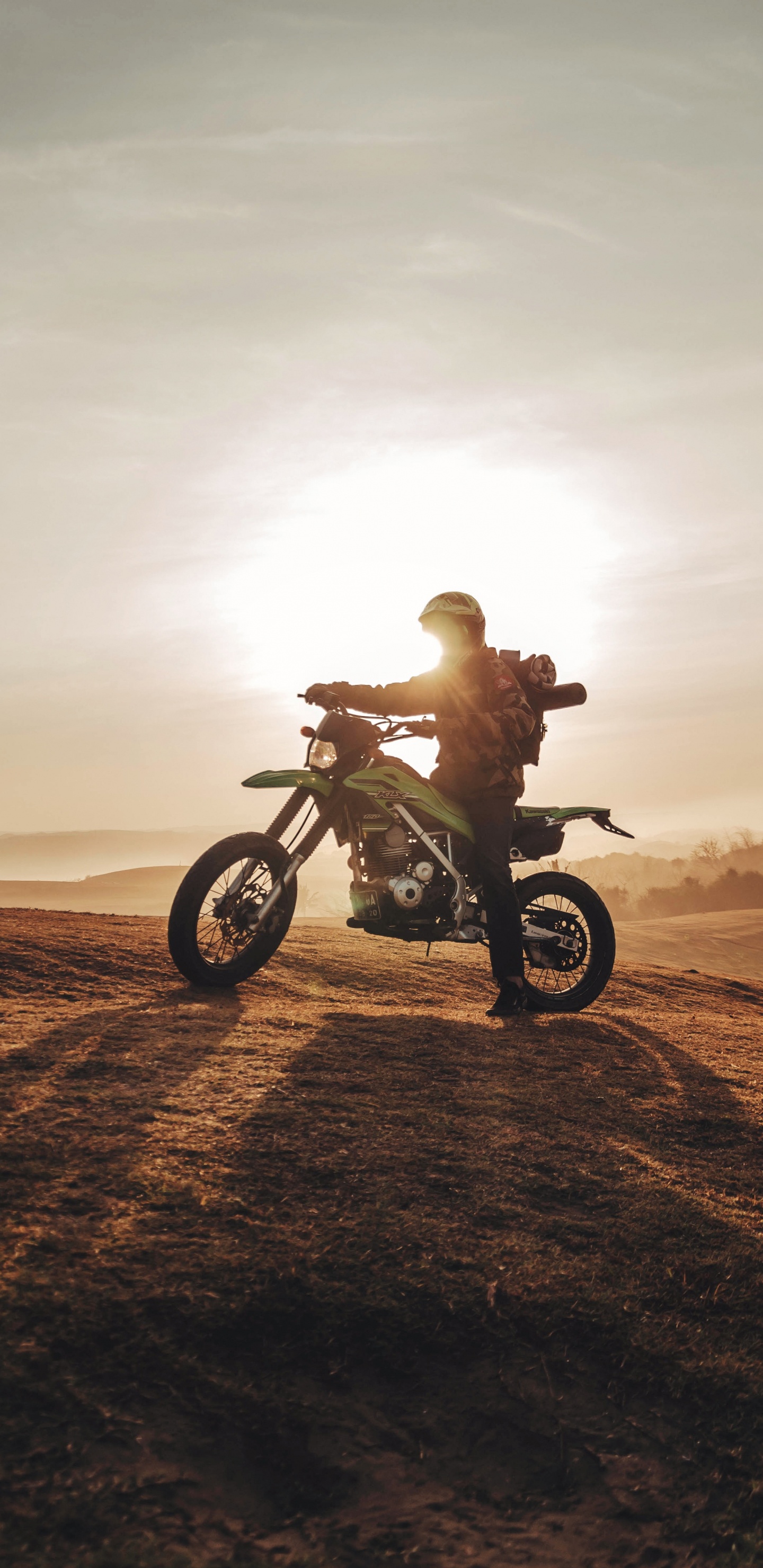 Man Riding Motorcycle on Brown Sand During Daytime. Wallpaper in 1440x2960 Resolution