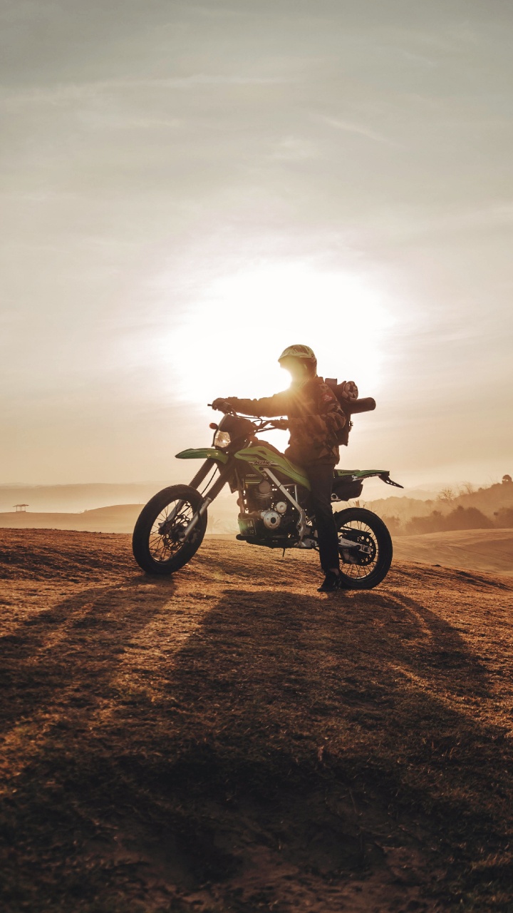 Mann, Der Tagsüber Auf Braunem Sand Motorrad Fährt. Wallpaper in 720x1280 Resolution