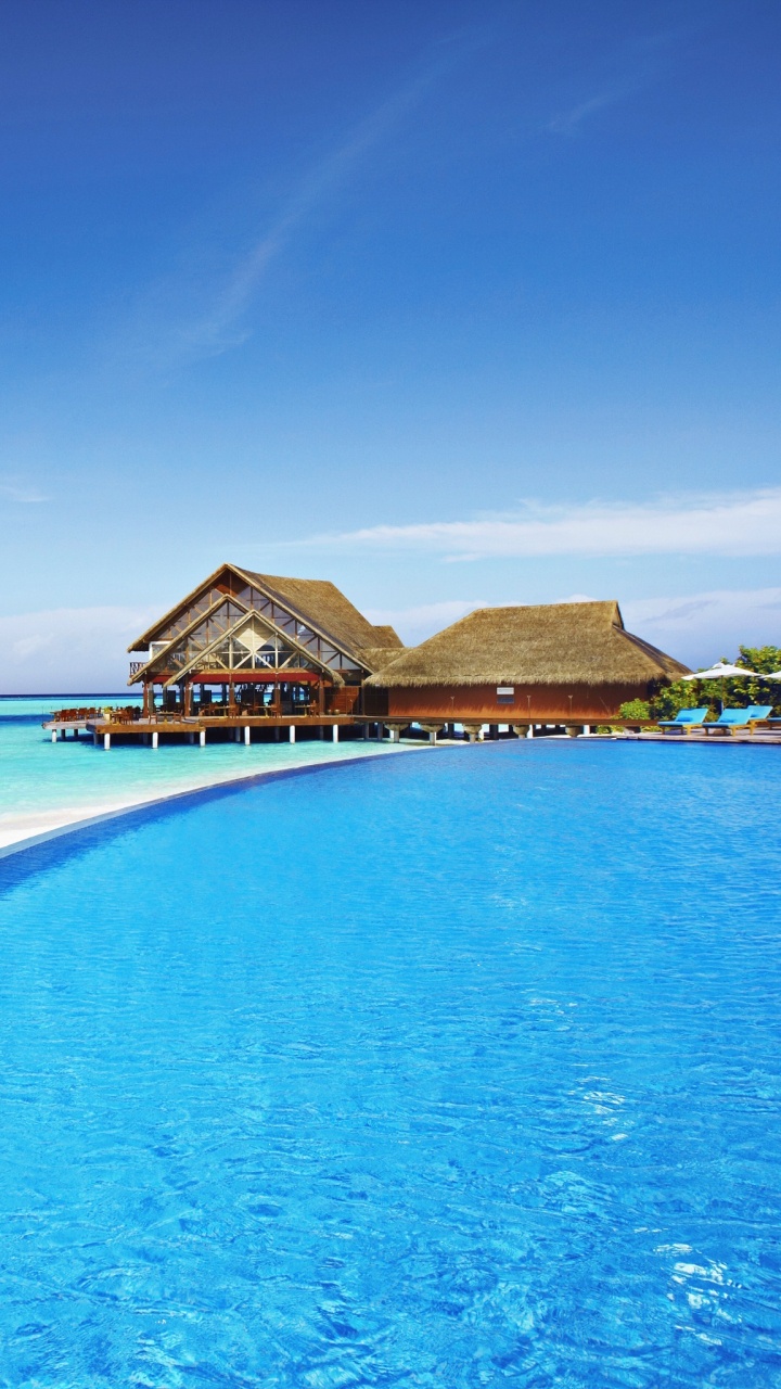 Brown Wooden House on Blue Sea Under Blue Sky During Daytime. Wallpaper in 720x1280 Resolution