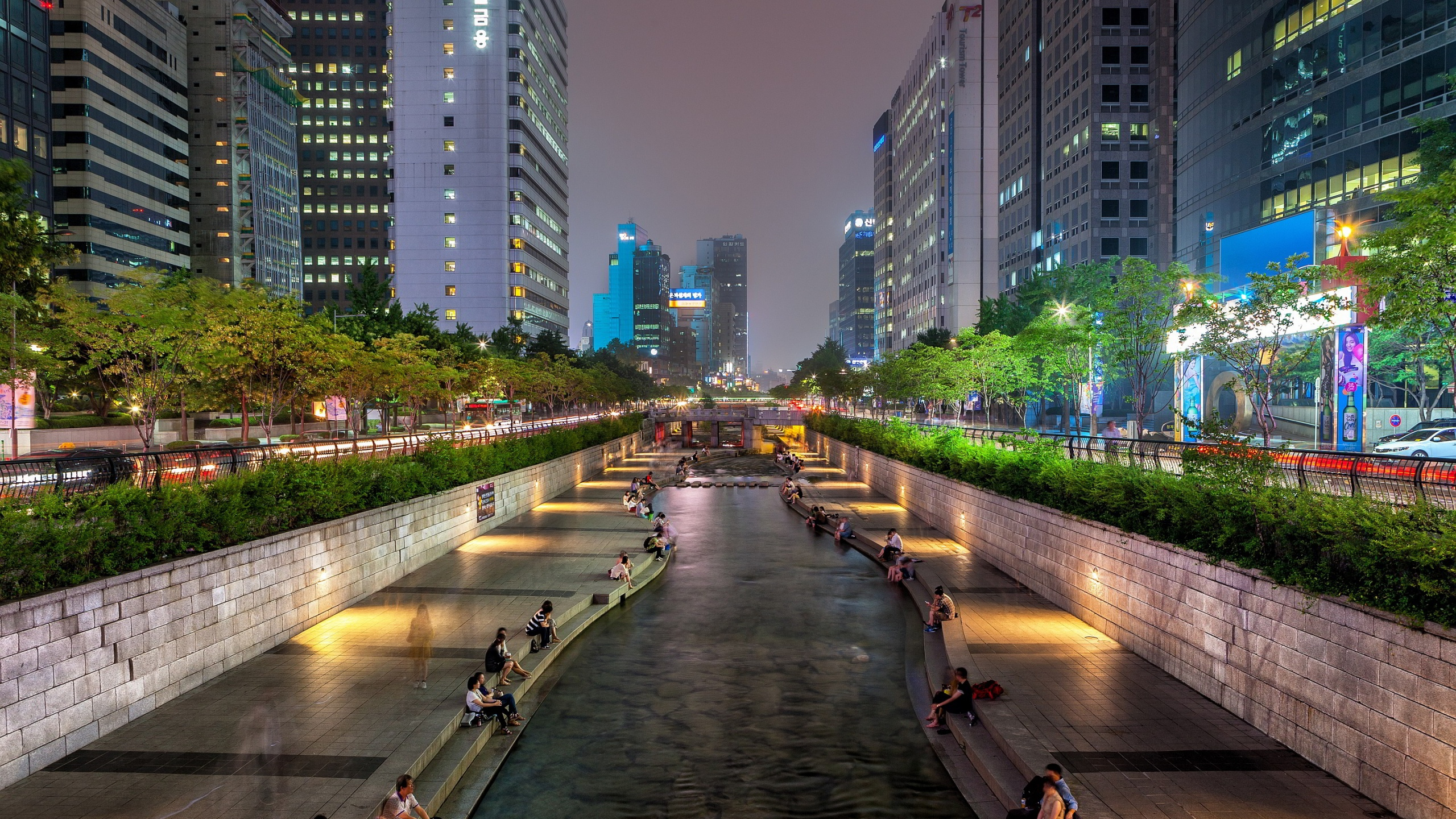 Personnes Marchant Sur le Trottoir Près Des Immeubles de Grande Hauteur Pendant la Nuit. Wallpaper in 2560x1440 Resolution
