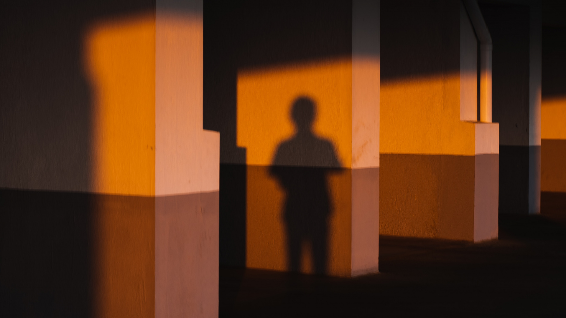 Silhouette Einer Person, Die Vor Einer Braunen Betonwand Steht. Wallpaper in 1920x1080 Resolution