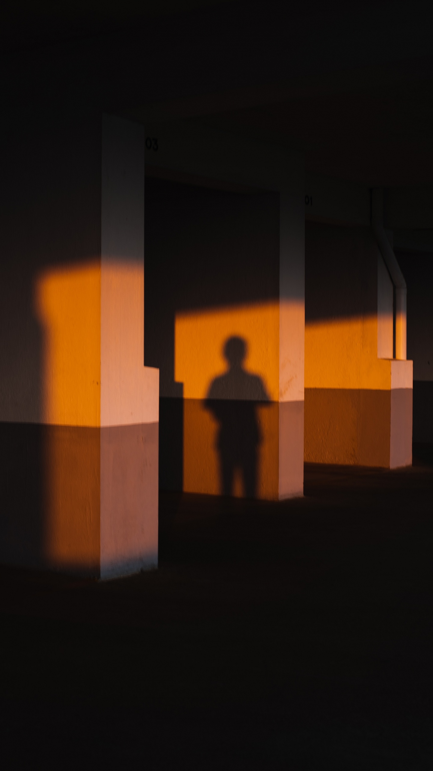 Silhouette of Person Standing in Front of Brown Concrete Wall. Wallpaper in 1440x2560 Resolution