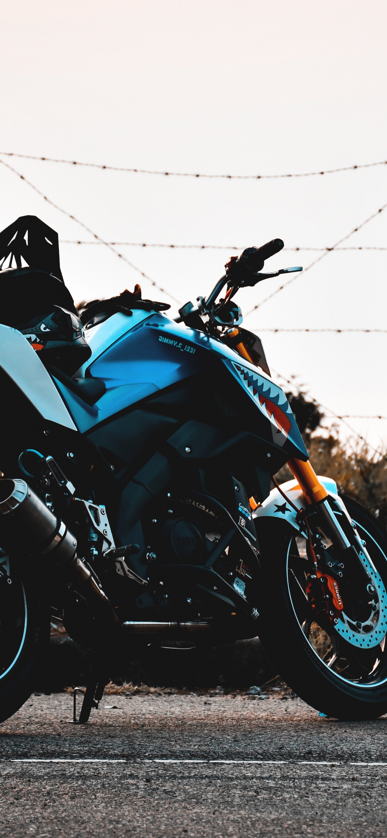 Schwarzes Und Blaues Sportfahrrad, Das Tagsüber Auf Einer Grauen Betonstraße Geparkt Ist. Wallpaper in 1242x2688 Resolution