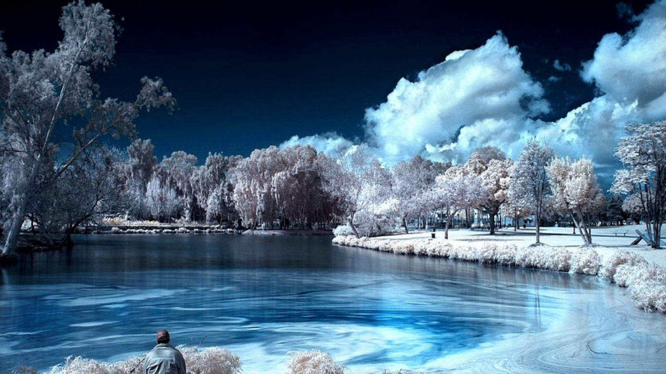 Man and Woman Sitting on Rock Near Body of Water During Daytime. Wallpaper in 1366x768 Resolution