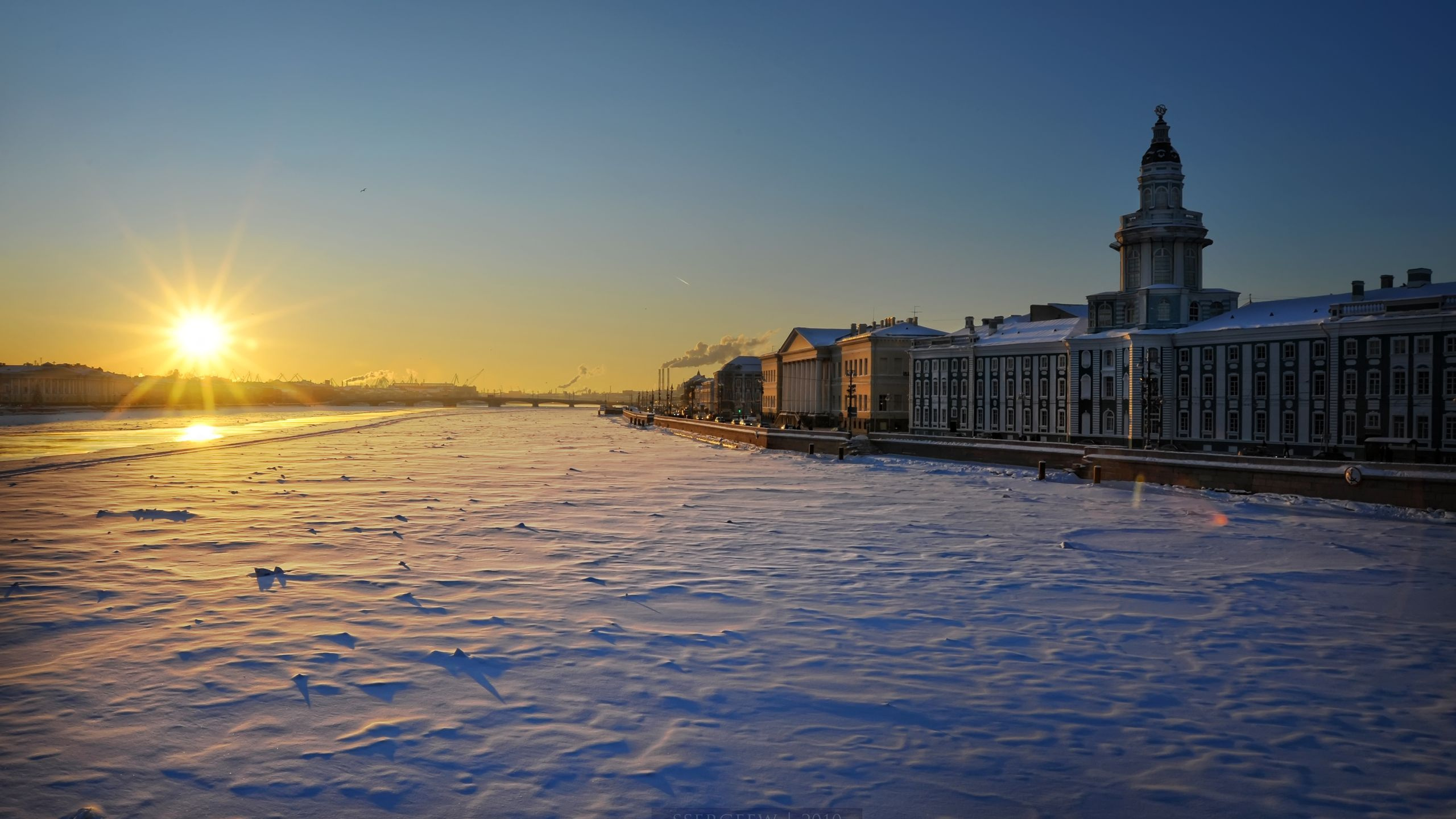 Weißes Und Braunes Betongebäude in Der Nähe Eines Gewässers Bei Sonnenuntergang. Wallpaper in 2560x1440 Resolution