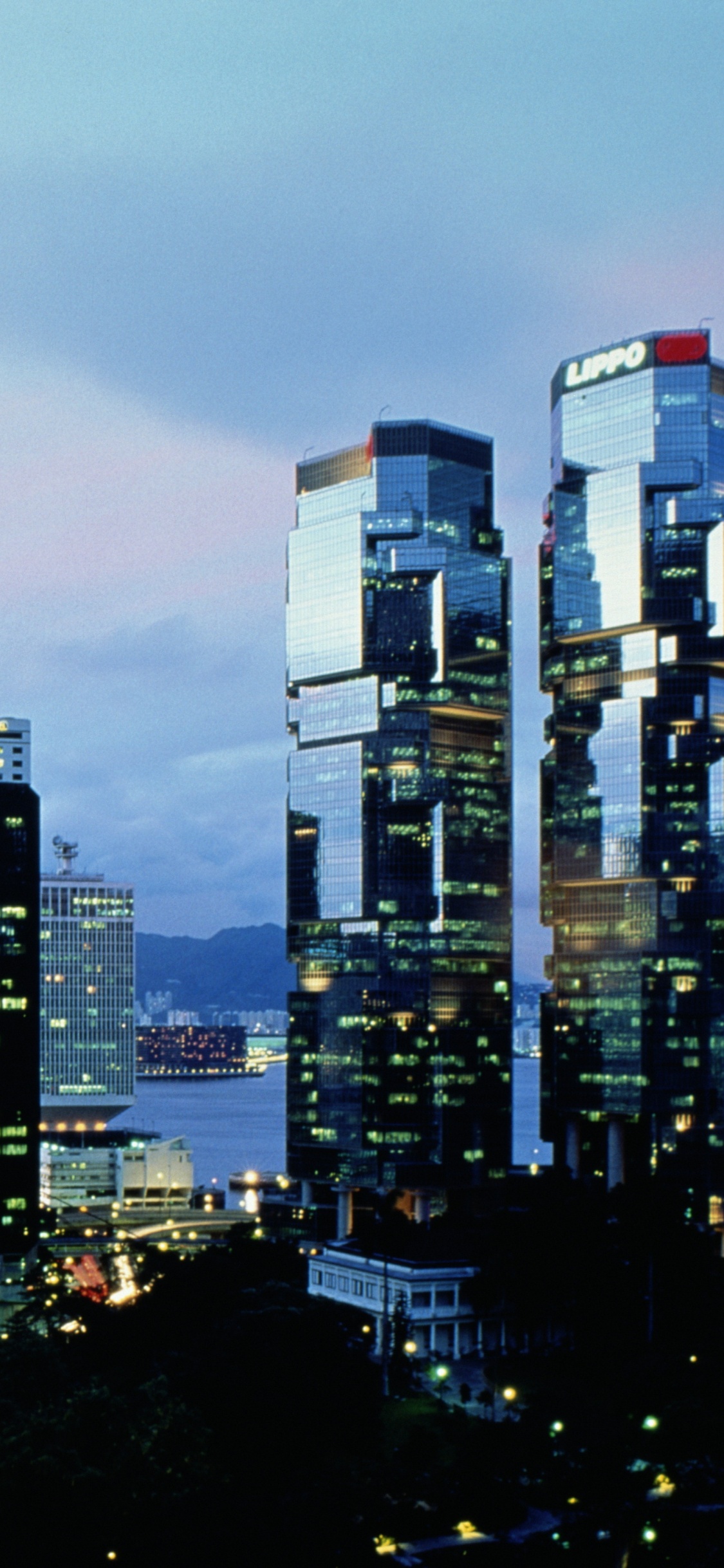City Buildings Under Gray Sky During Night Time. Wallpaper in 1125x2436 Resolution
