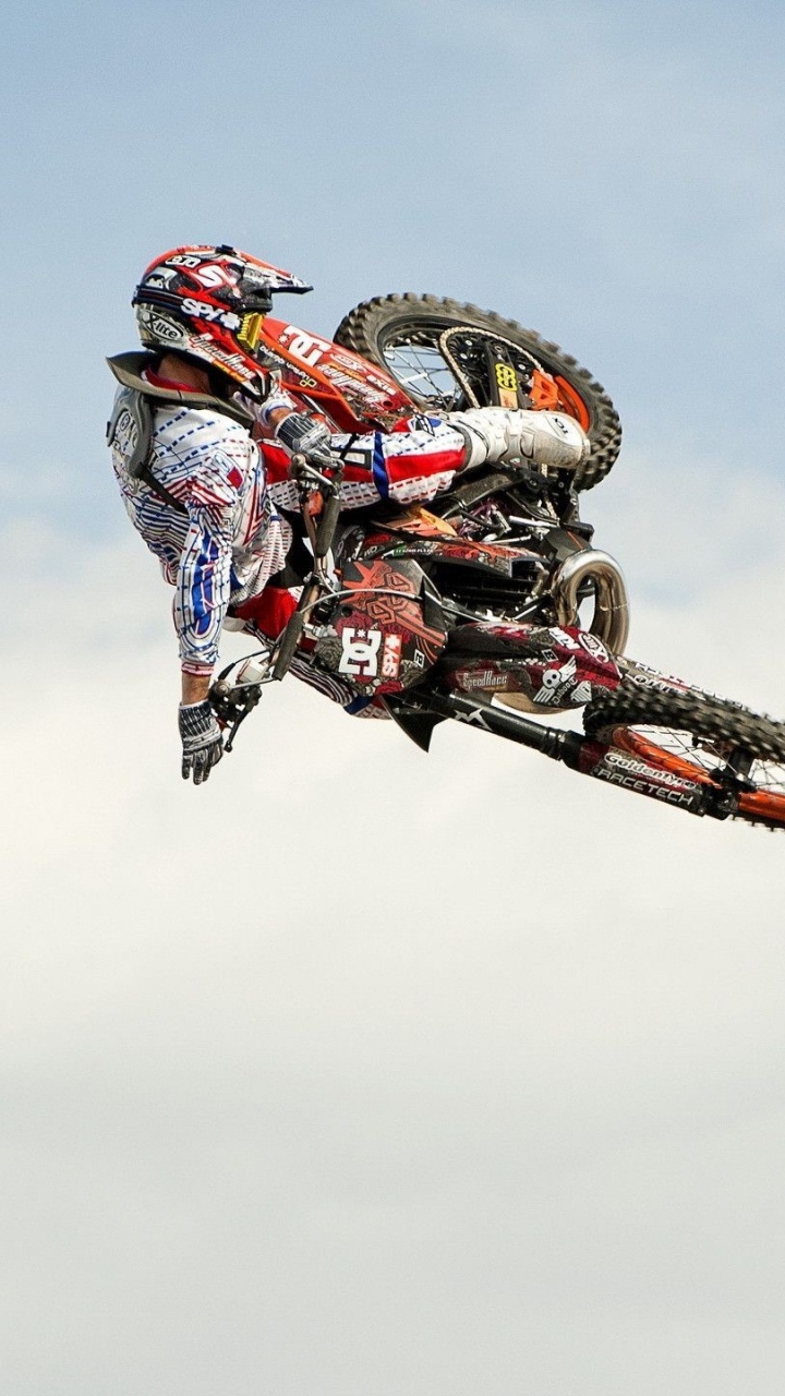 Mann, Der Tagsüber Motocross-Dirt-Bike Fährt, Stunts Unter Blauem Himmel Macht. Wallpaper in 720x1280 Resolution