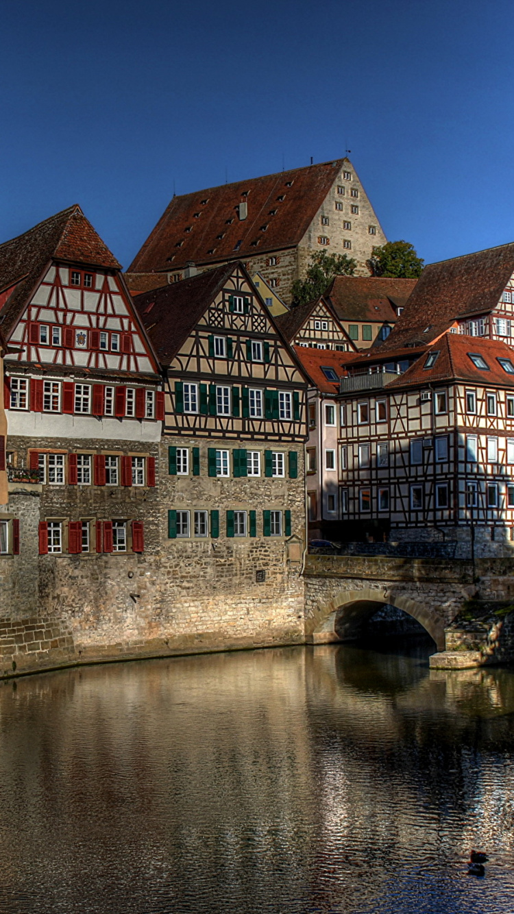 Brown and White Concrete Building Beside River During Daytime. Wallpaper in 750x1334 Resolution
