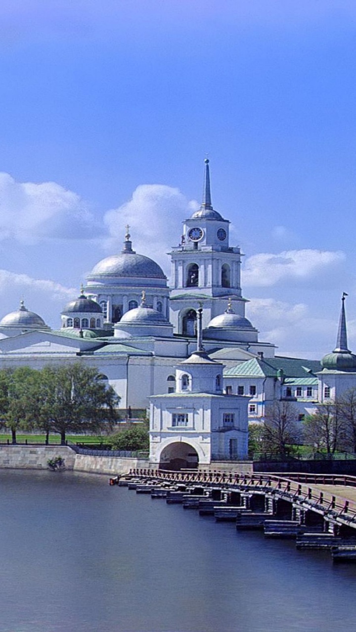White and Brown Concrete Building Near Body of Water During Daytime. Wallpaper in 720x1280 Resolution