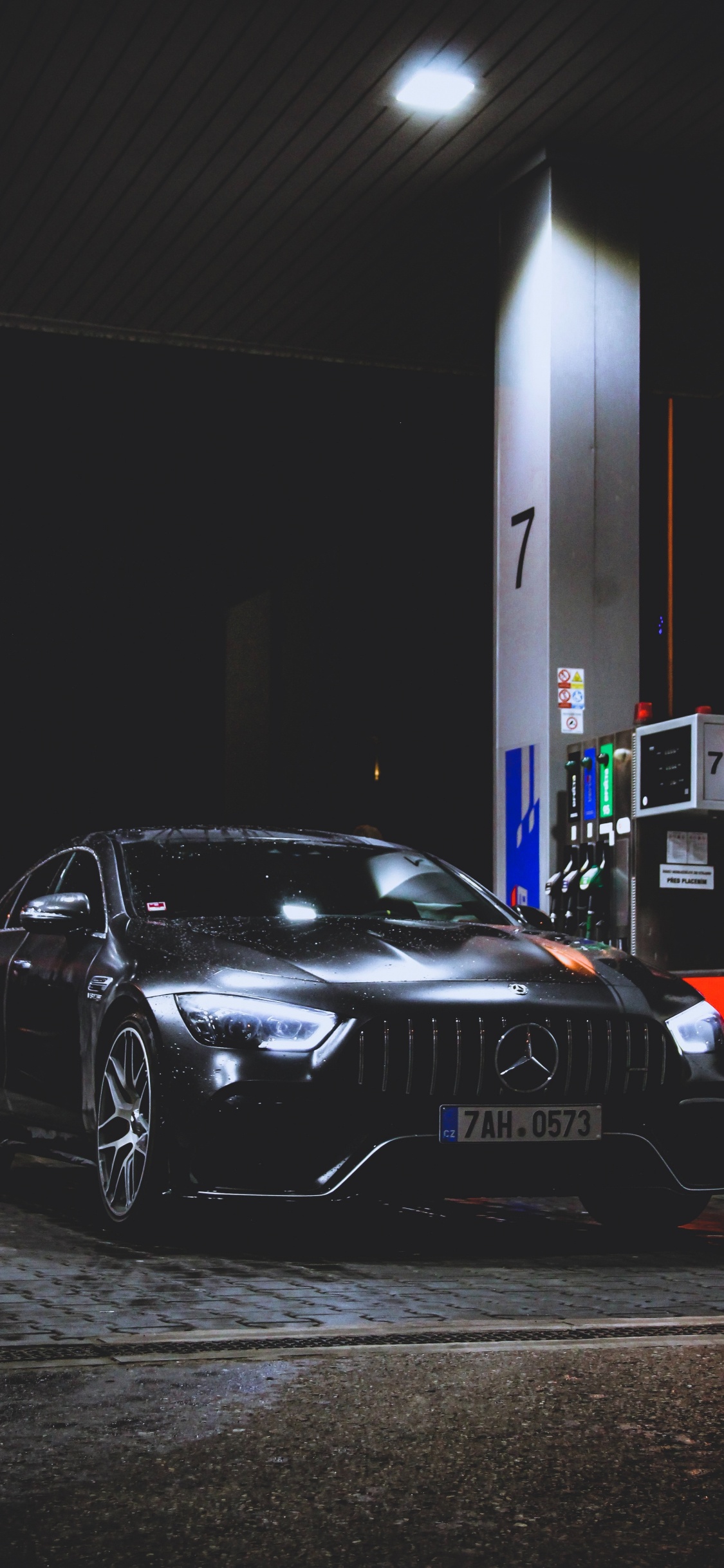 Porsche 911 Noire Garée Devant le Bâtiment Rouge et Blanc. Wallpaper in 1125x2436 Resolution