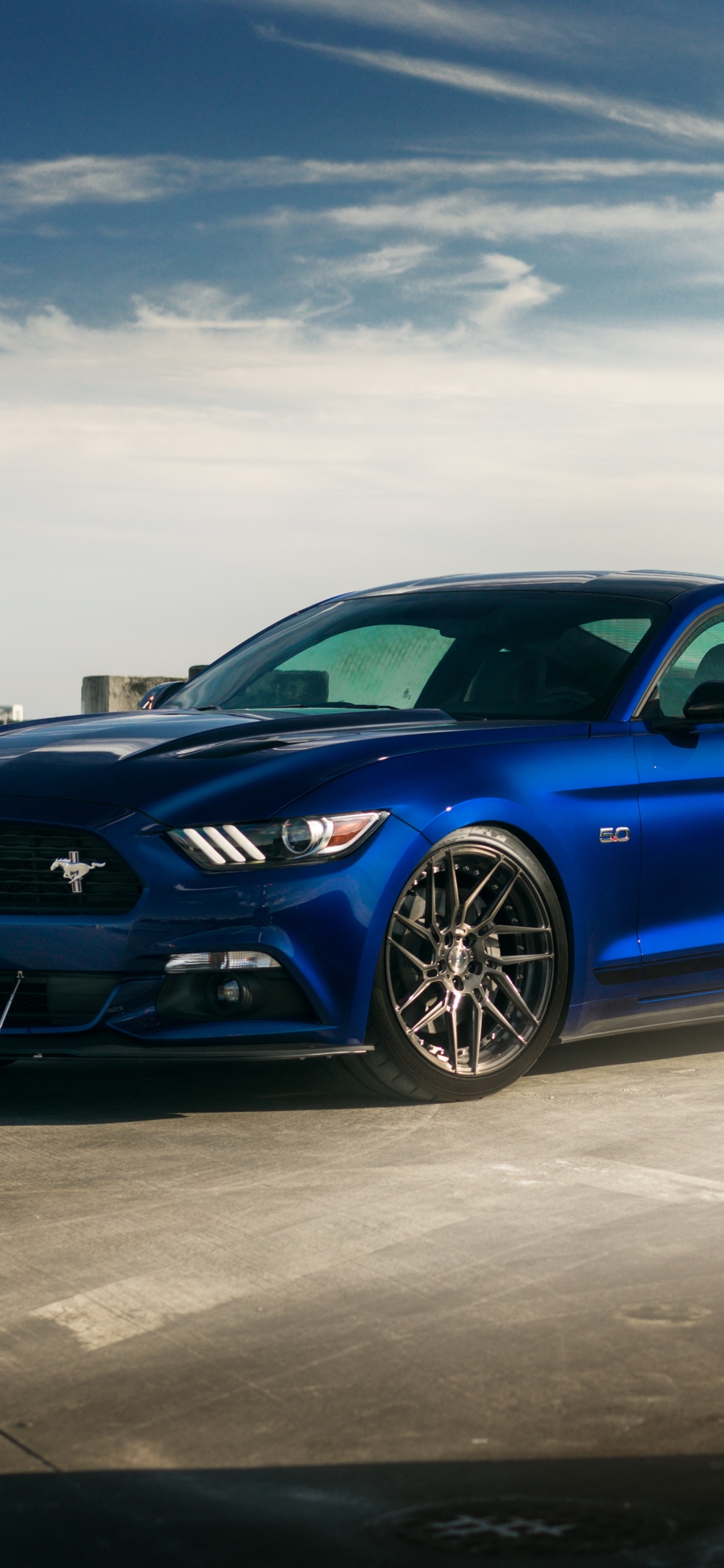 Blue Bmw m 3 Coupe Parked on Gray Concrete Pavement Under White Clouds During Daytime. Wallpaper in 1125x2436 Resolution