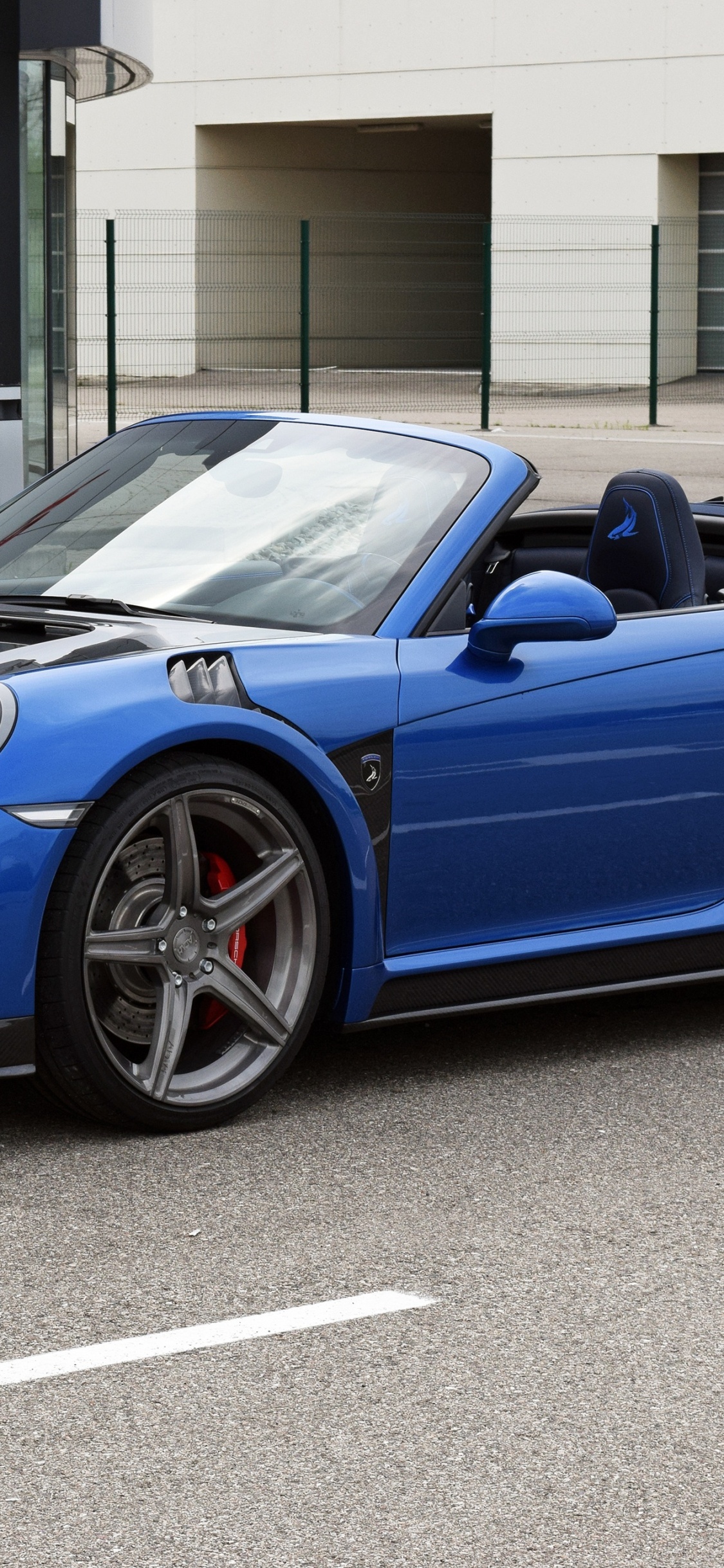 Porsche 911 Azul Estacionado Cerca Del Edificio Durante el Día. Wallpaper in 1125x2436 Resolution