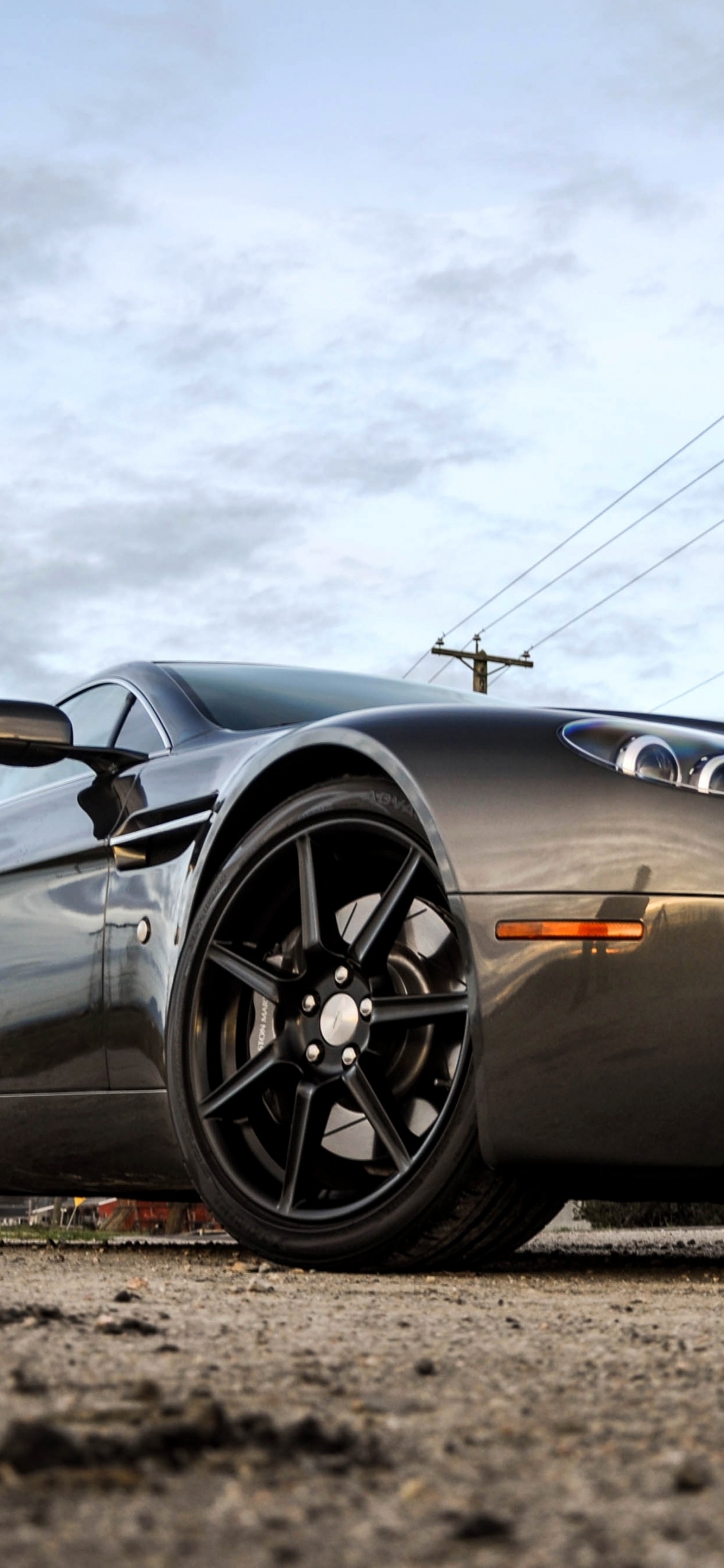 Porsche 911 Negro en la Carretera Bajo Nubes Blancas. Wallpaper in 1125x2436 Resolution