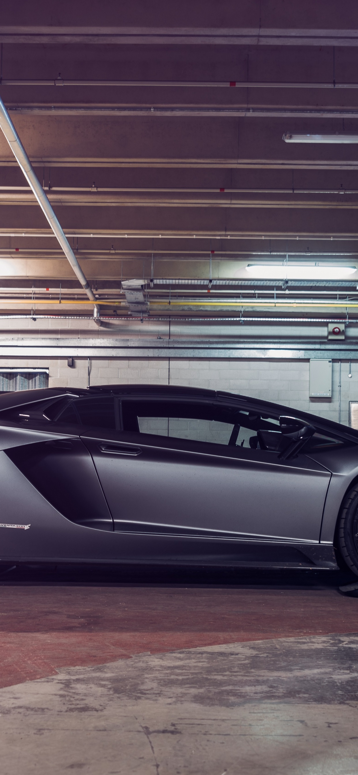 Black Coupe Parked in a Parking Lot. Wallpaper in 1242x2688 Resolution