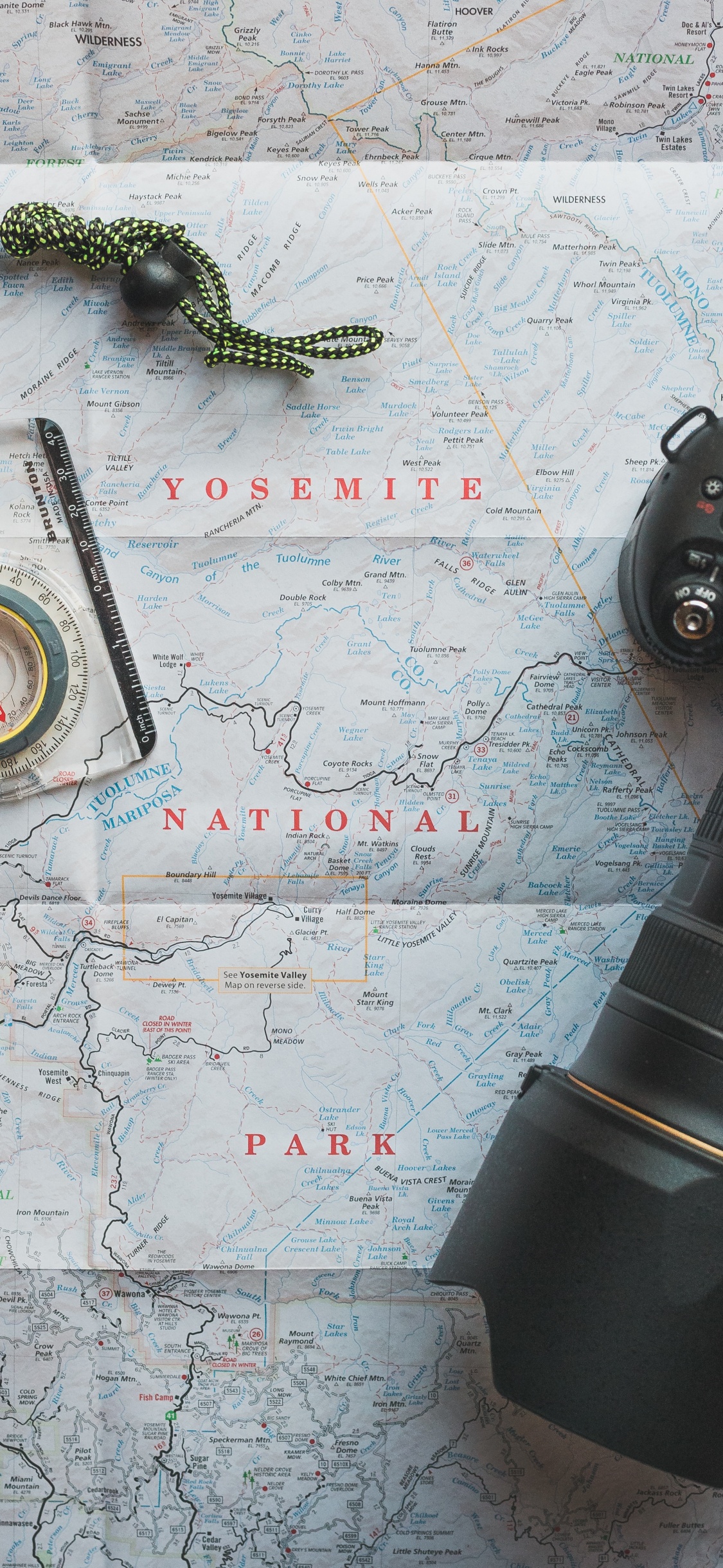 Black Camera Lens on White and Blue Map. Wallpaper in 1125x2436 Resolution