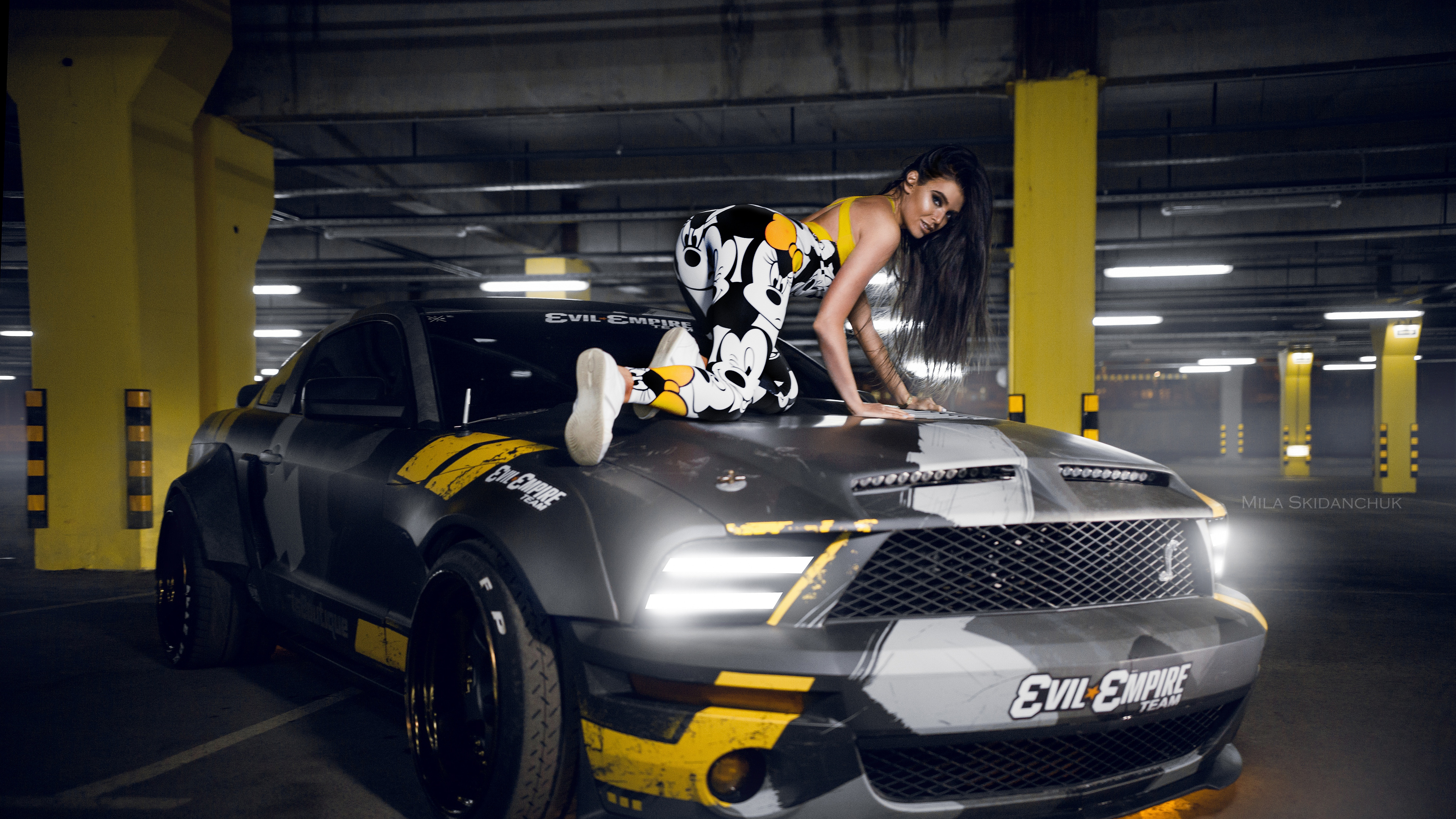 Woman in Black and White Floral Dress Riding on Black and Yellow Sports Car. Wallpaper in 3840x2160 Resolution