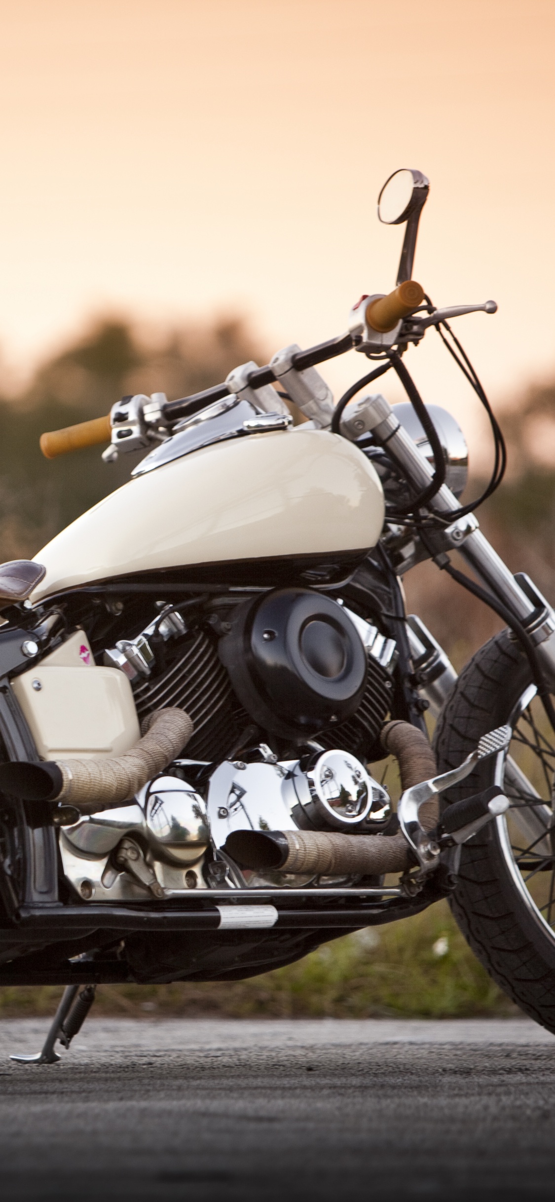 Weißes Und Schwarzes Motorrad Tagsüber Unterwegs. Wallpaper in 1125x2436 Resolution