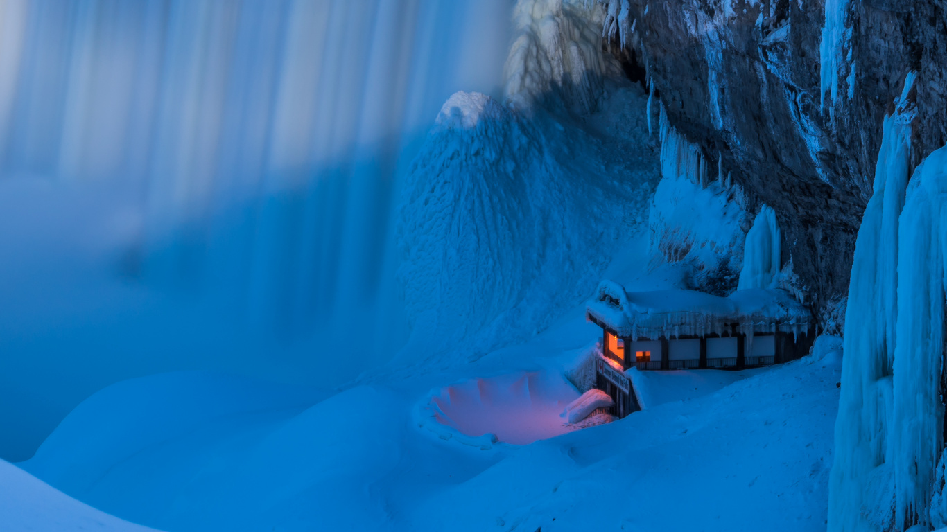 Person in Orangefarbener Jacke, Die Tagsüber Auf Einem Braunen Holzdock in Der Nähe Eines Weißen Schneebedeckten Berges Sitzt. Wallpaper in 1366x768 Resolution