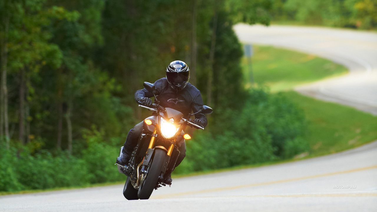 Mann Mit Schwarzem Helm, Der Tagsüber Gelbes Motorrad Auf Der Straße Fährt. Wallpaper in 1280x720 Resolution