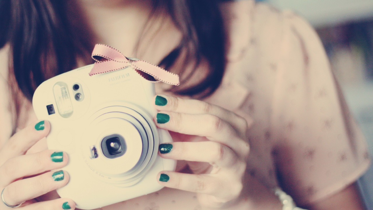 Woman Holding White Point and Shoot Camera. Wallpaper in 1280x720 Resolution