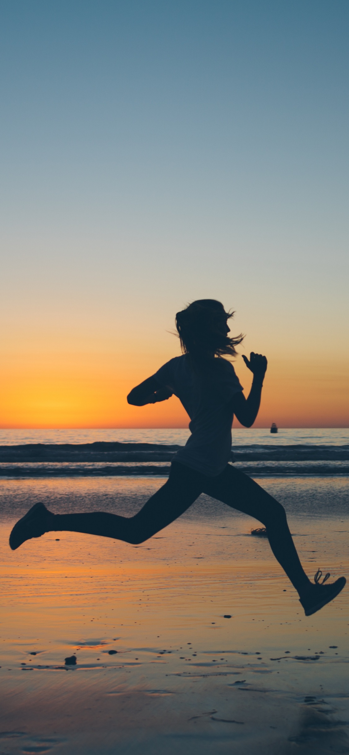 Silhouette of Man Jumping on Beach During Sunset. Wallpaper in 1125x2436 Resolution