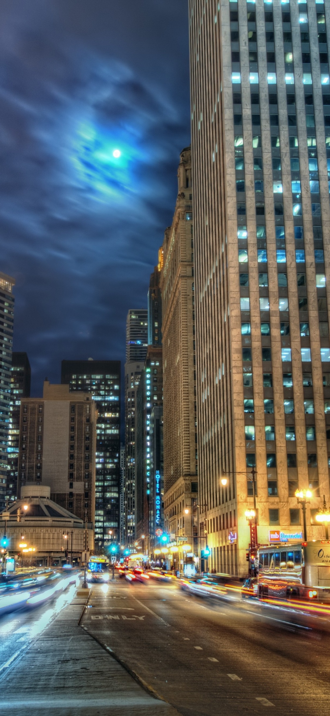 Autos Auf Der Straße in Der Nähe Von Hochhäusern Während Der Nacht. Wallpaper in 1125x2436 Resolution