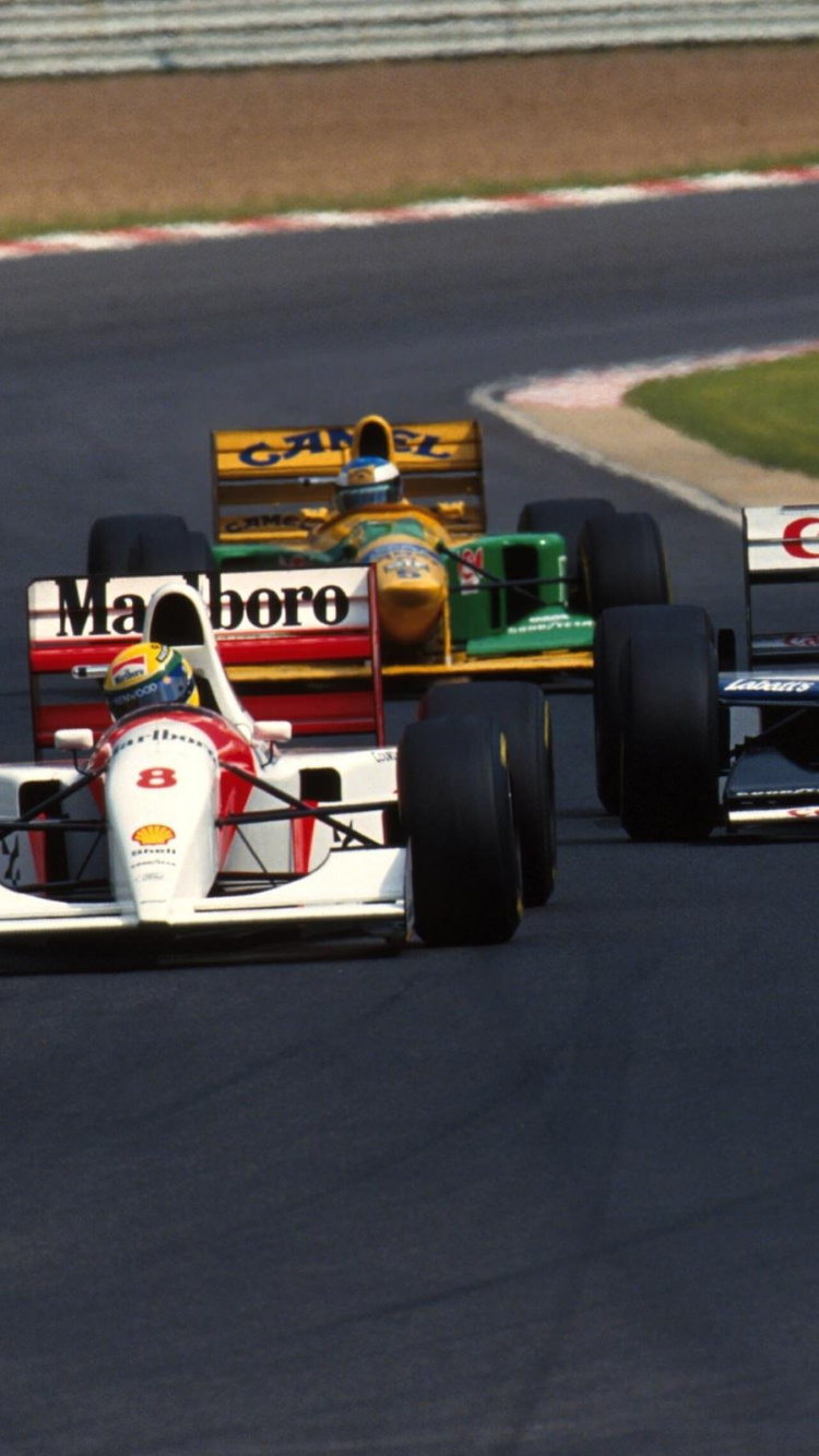 White and Red Formula 1 on Race Track. Wallpaper in 750x1334 Resolution