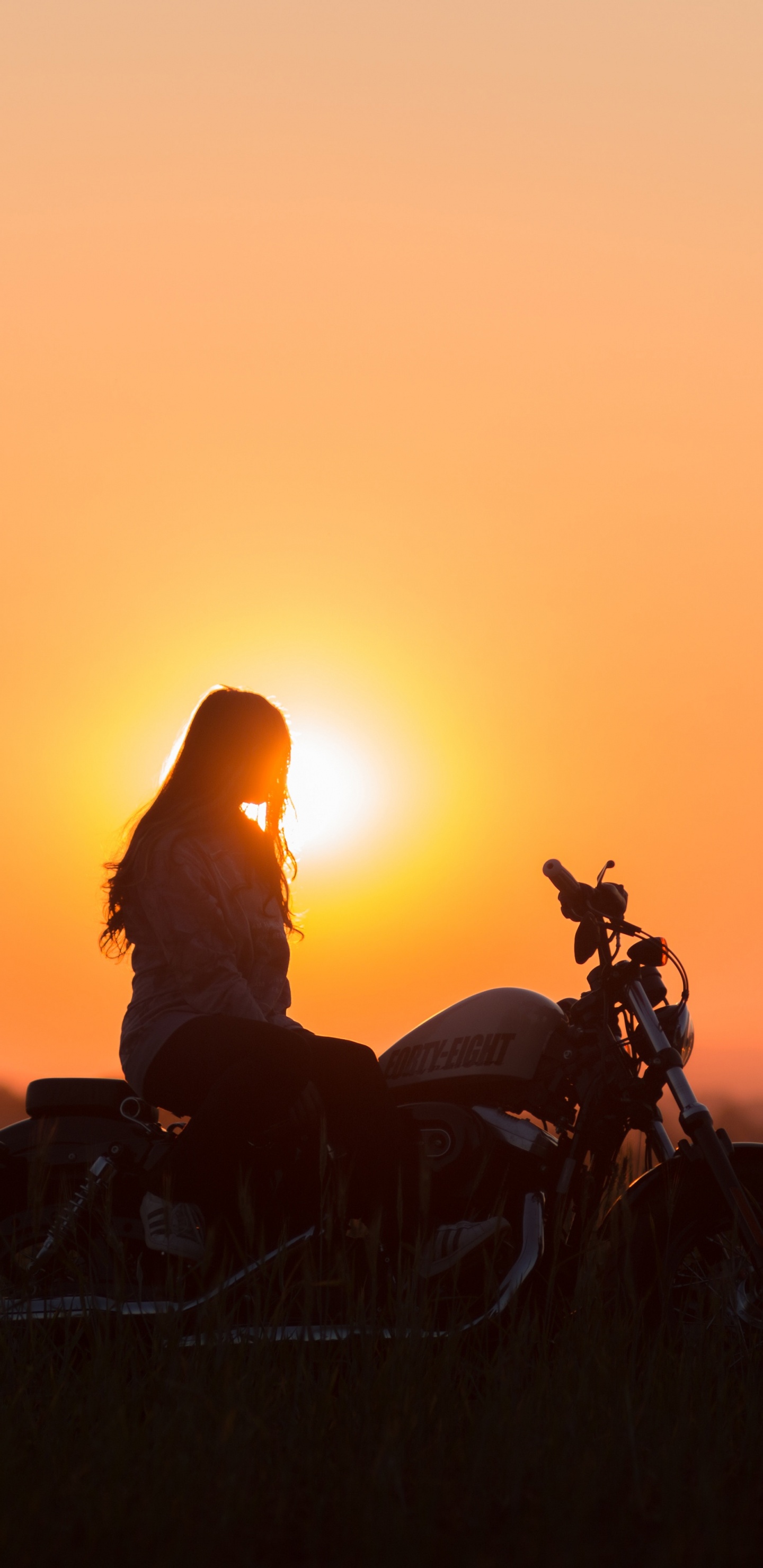 Silhouette Eines Mannes, Der Während Des Sonnenuntergangs Motorrad Fährt. Wallpaper in 1440x2960 Resolution
