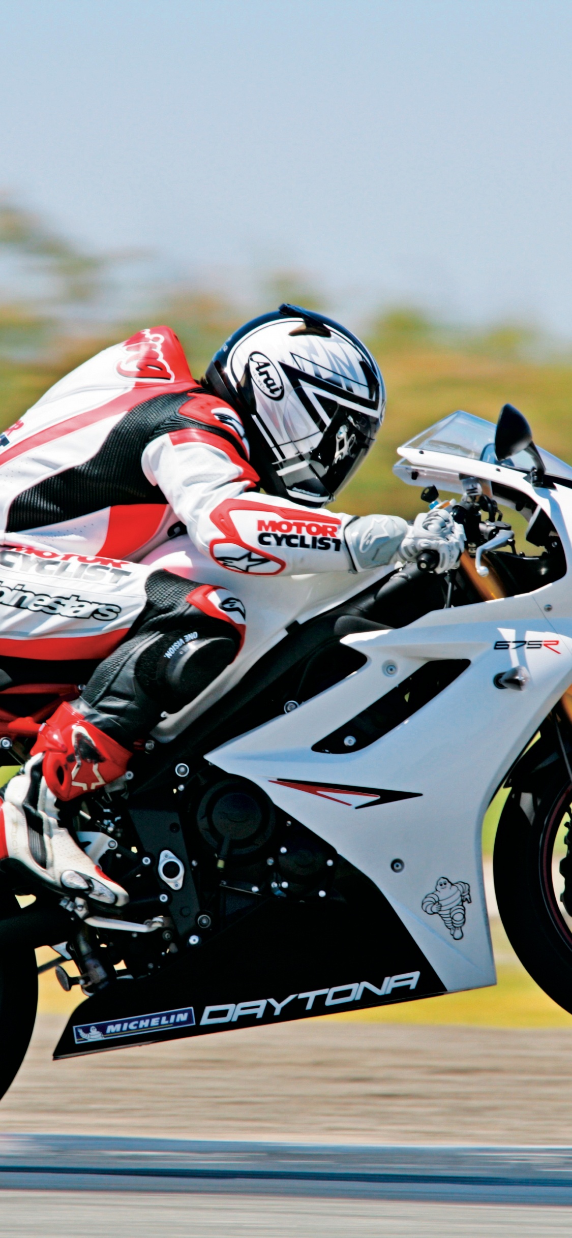 Man in Red and White Motorcycle Helmet Riding on White and Blue Sports Bike. Wallpaper in 1125x2436 Resolution