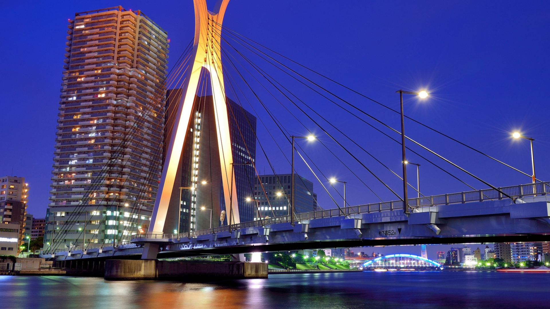 Puente Sobre el Agua Cerca de un Edificio de Gran Altura Durante la Noche. Wallpaper in 1920x1080 Resolution