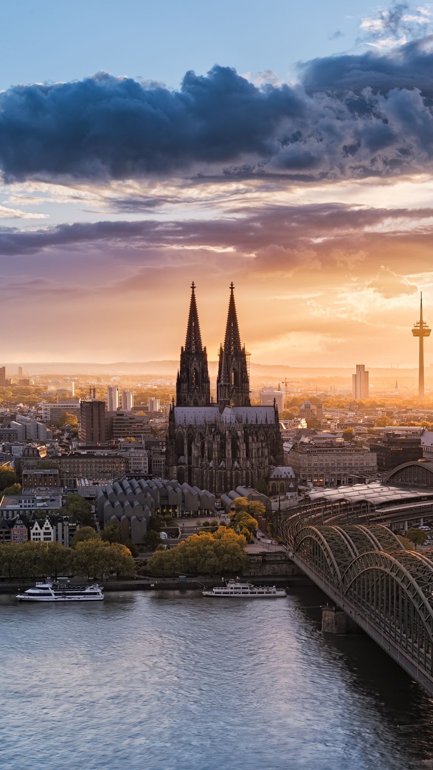 Bridge Over River Near City Buildings During Sunset. Wallpaper in 1440x2560 Resolution