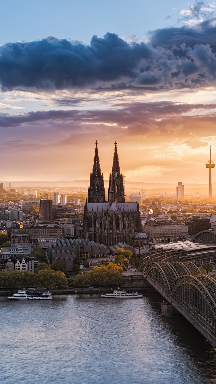 Bridge Over River Near City Buildings During Sunset. Wallpaper in 750x1334 Resolution