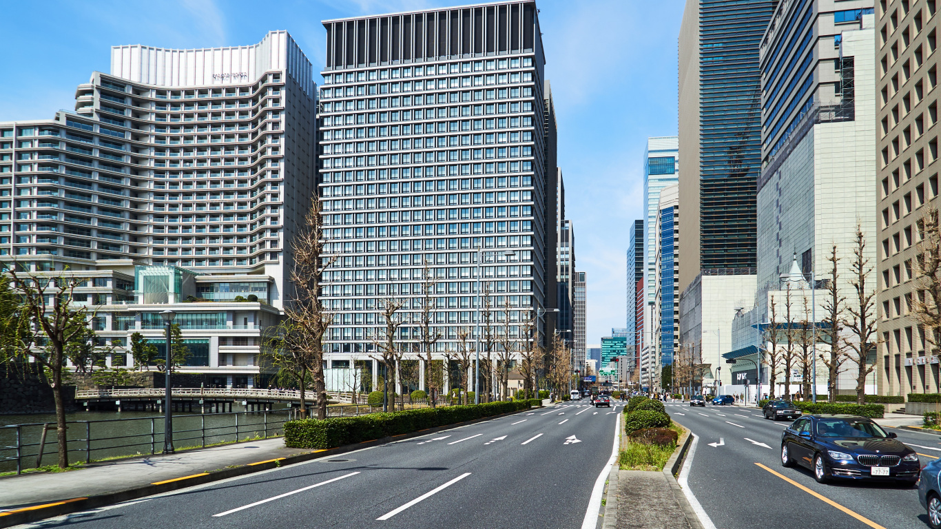 Gray Concrete Road Between High Rise Buildings During Daytime. Wallpaper in 1366x768 Resolution