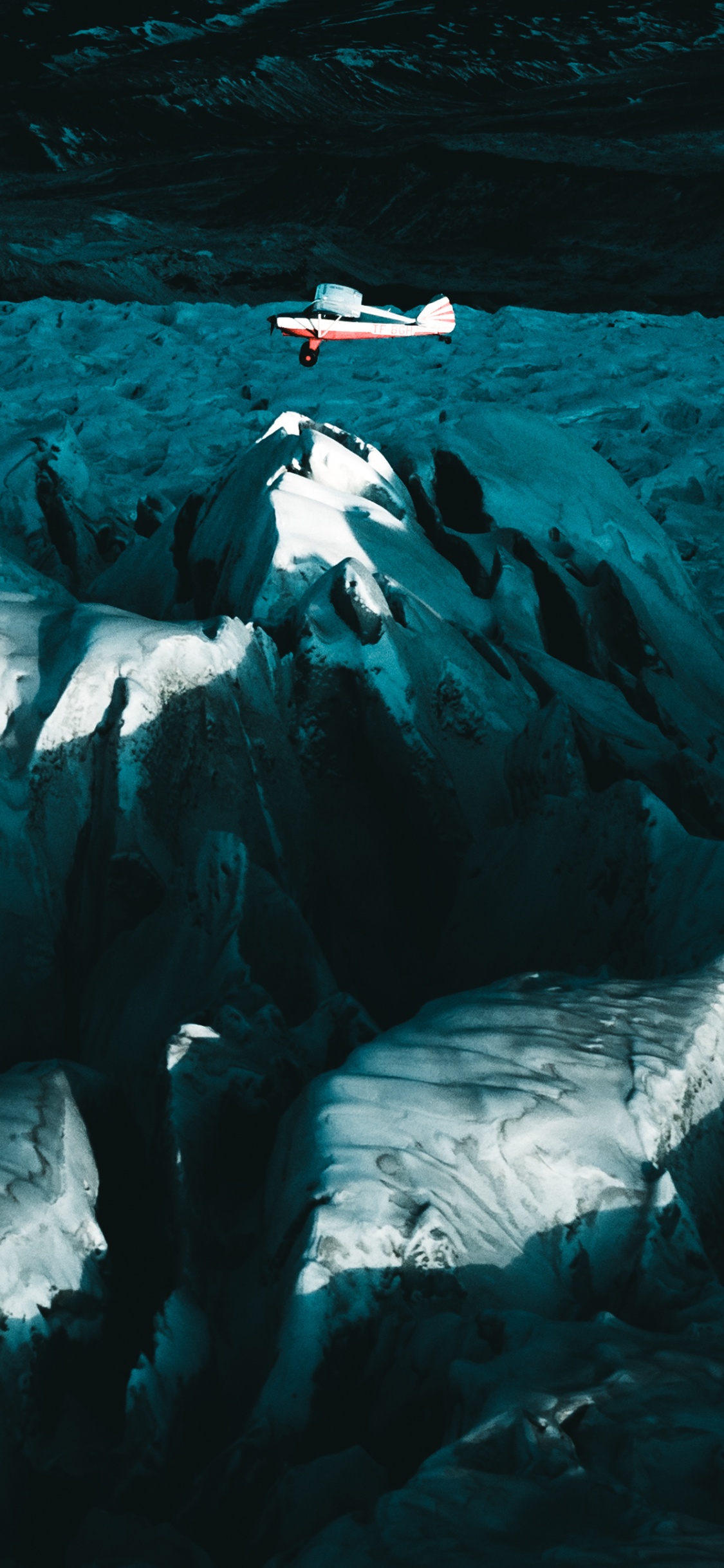 Persona Con Camisa Negra Sentada en la Formación de Roca Blanca. Wallpaper in 1125x2436 Resolution