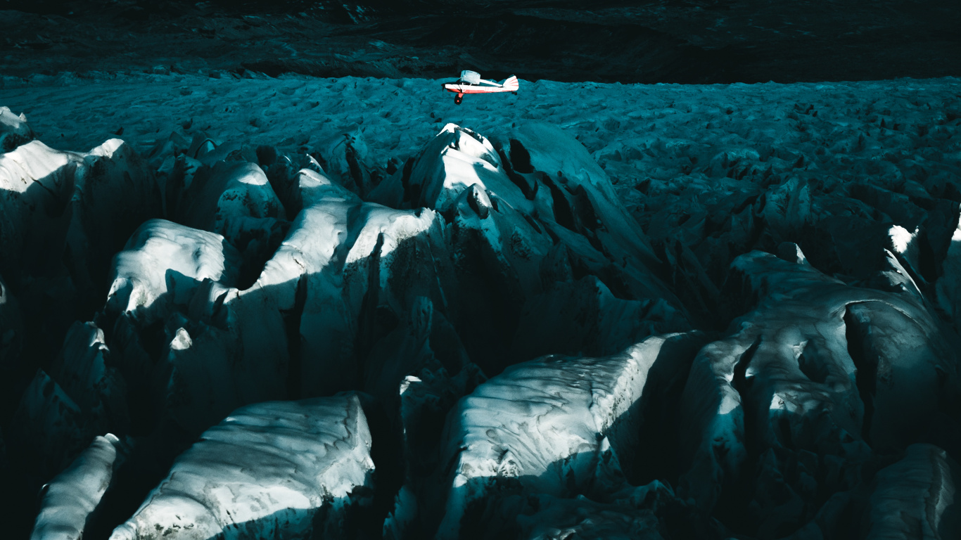 Person in Black Shirt Sitting on White Rock Formation. Wallpaper in 1366x768 Resolution