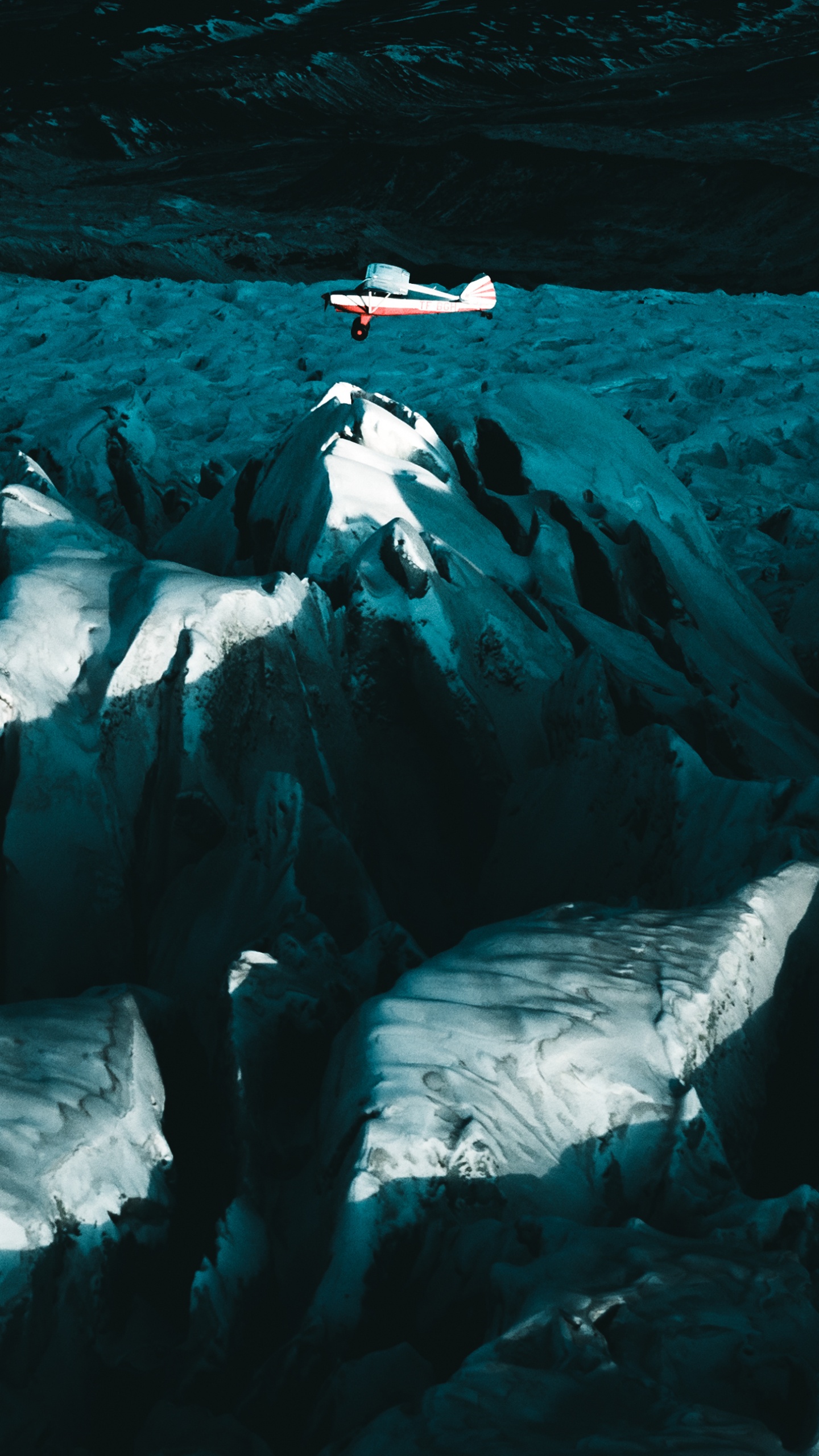 Person in Black Shirt Sitting on White Rock Formation. Wallpaper in 1440x2560 Resolution