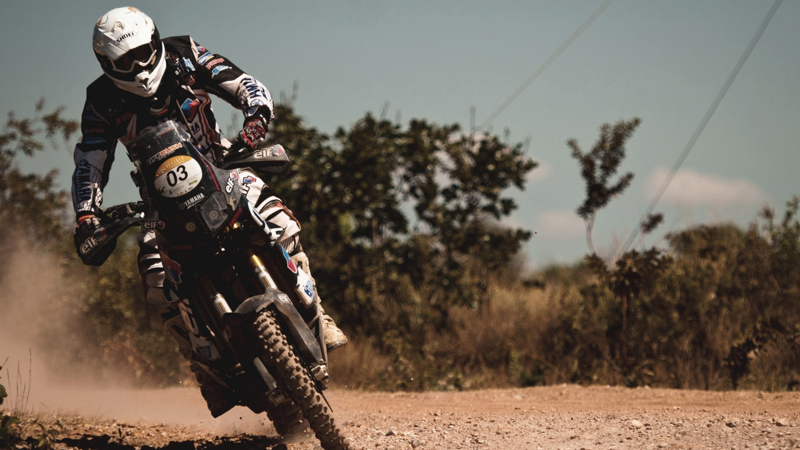Man in Black and White Motorcycle Suit Riding Motocross Dirt Bike. Wallpaper in 2560x1440 Resolution