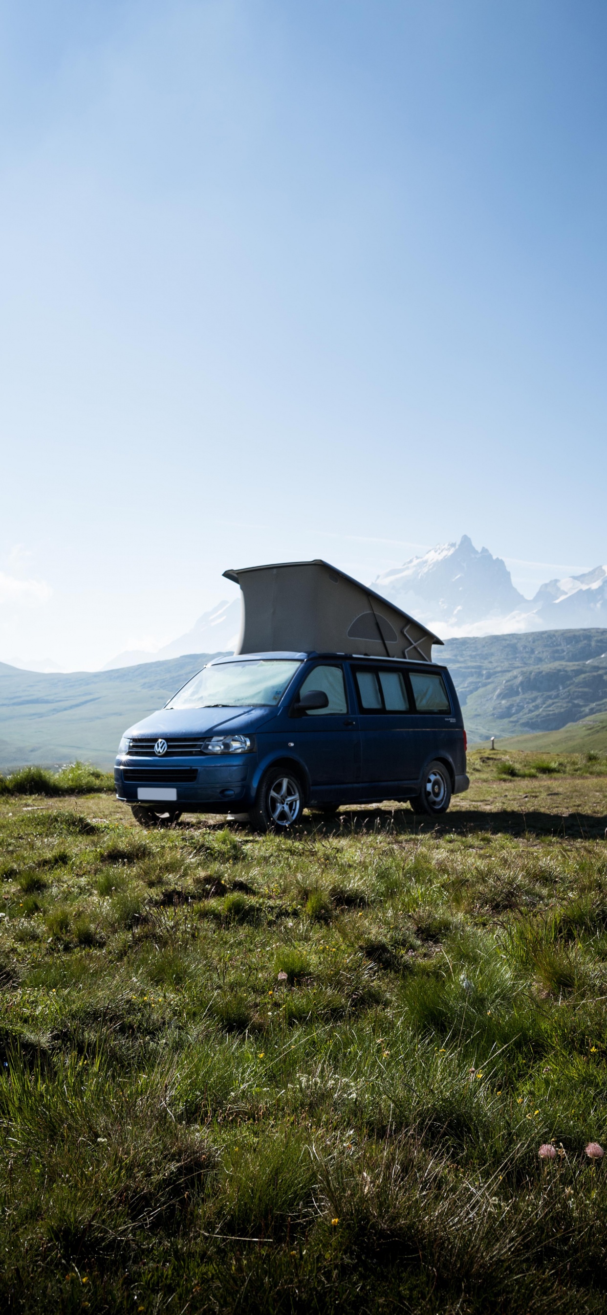 Suv Bleu Sur Champ D'herbe Verte Près de la Montagne Pendant la Journée. Wallpaper in 1242x2688 Resolution