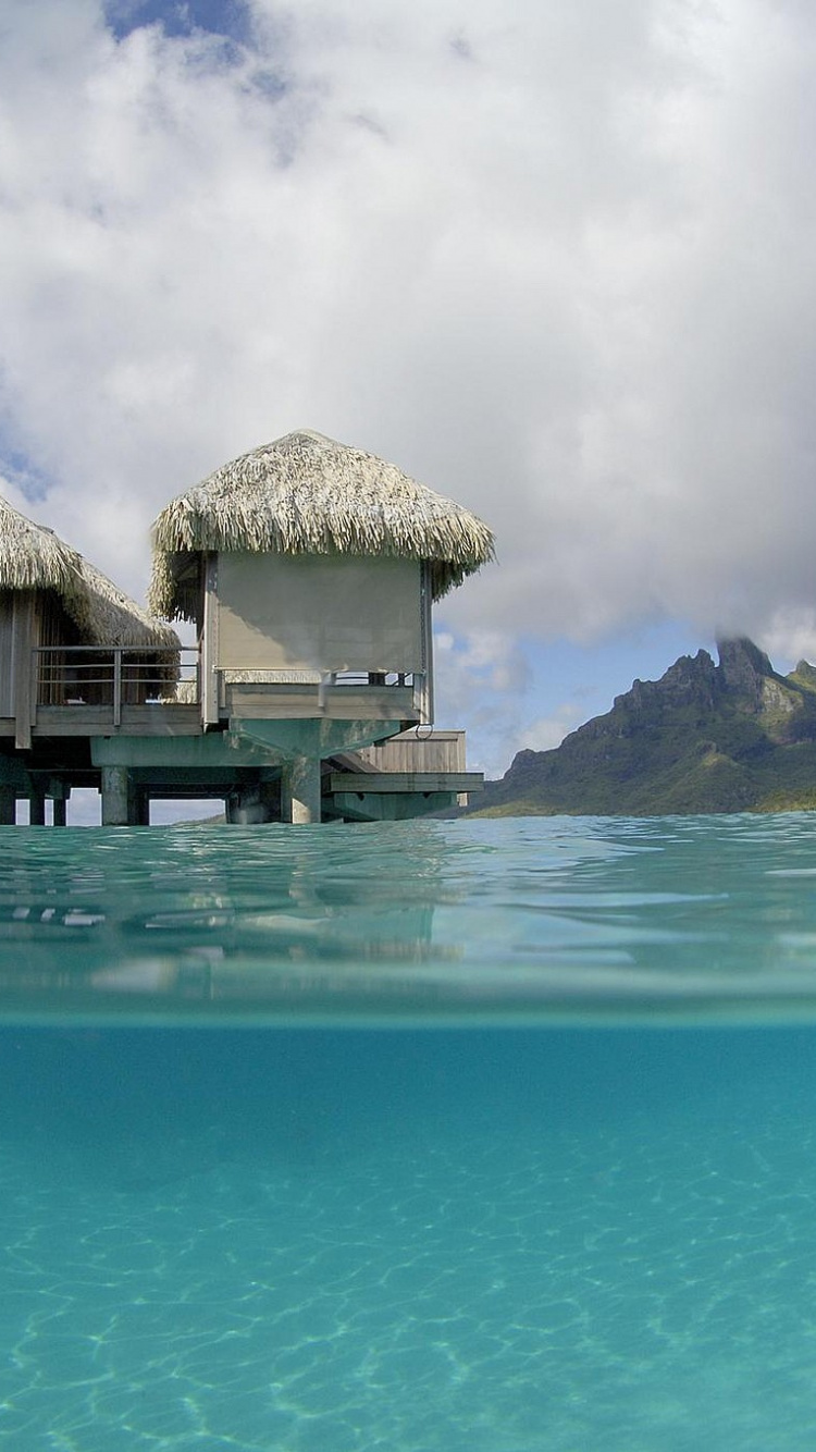 Brown Wooden House on Blue Sea Under Blue Sky During Daytime. Wallpaper in 750x1334 Resolution