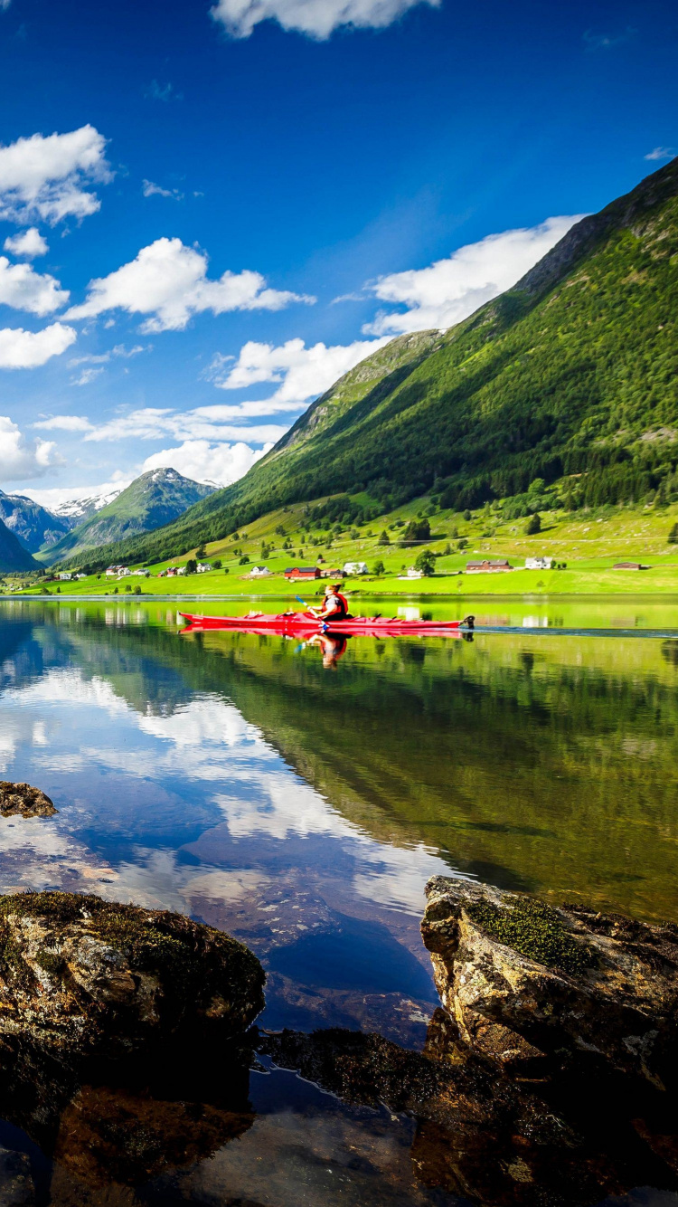 Montañas Verdes Cerca Del Lago Bajo un Cielo Azul Durante el Día. Wallpaper in 750x1334 Resolution