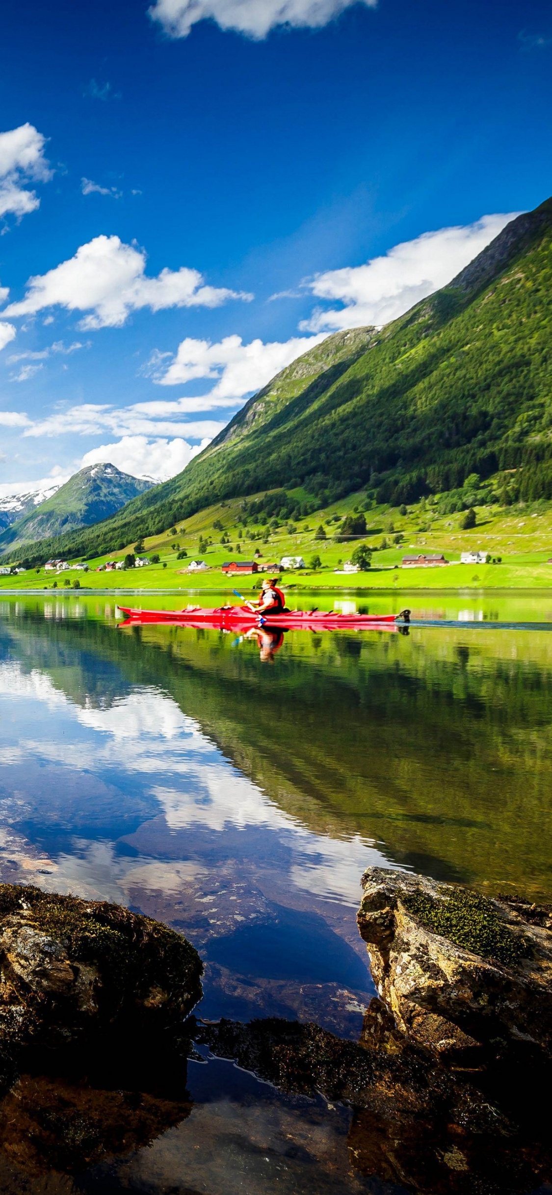 Green Mountains Near Lake Under Blue Sky During Daytime. Wallpaper in 1125x2436 Resolution