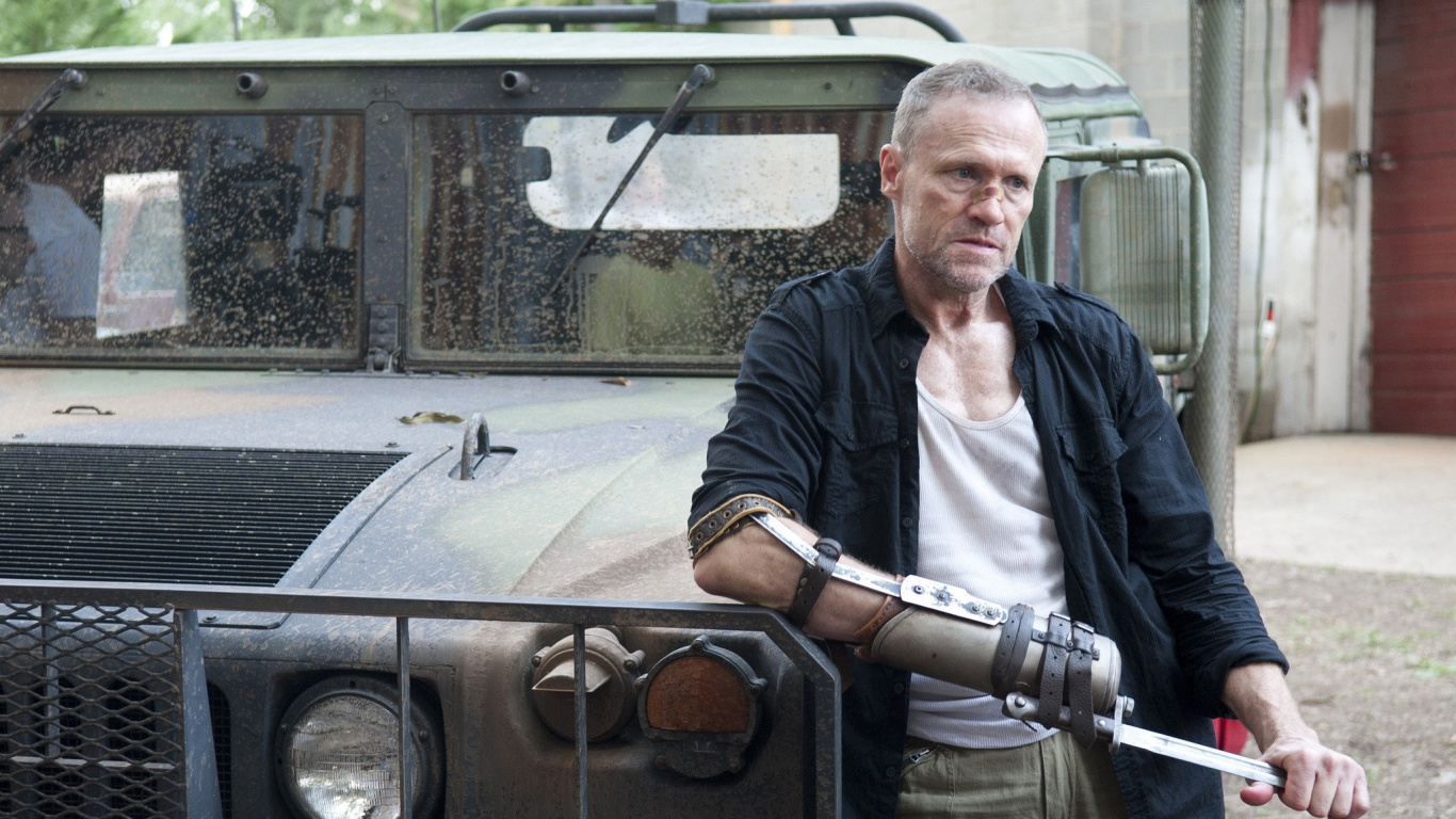 Mann in Schwarzer Jacke Und Grüner Hose Sitzt Auf Schwarzem Auto. Wallpaper in 1366x768 Resolution